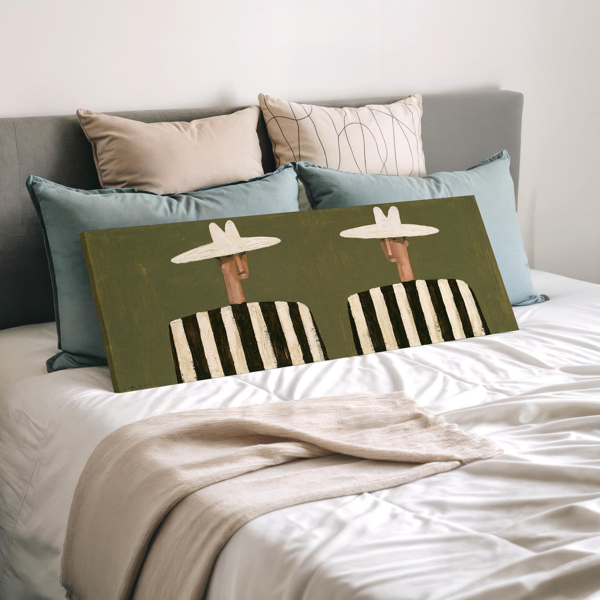 Two figures in striped shirts wide panoramic canvas print laid on a bed to show its size