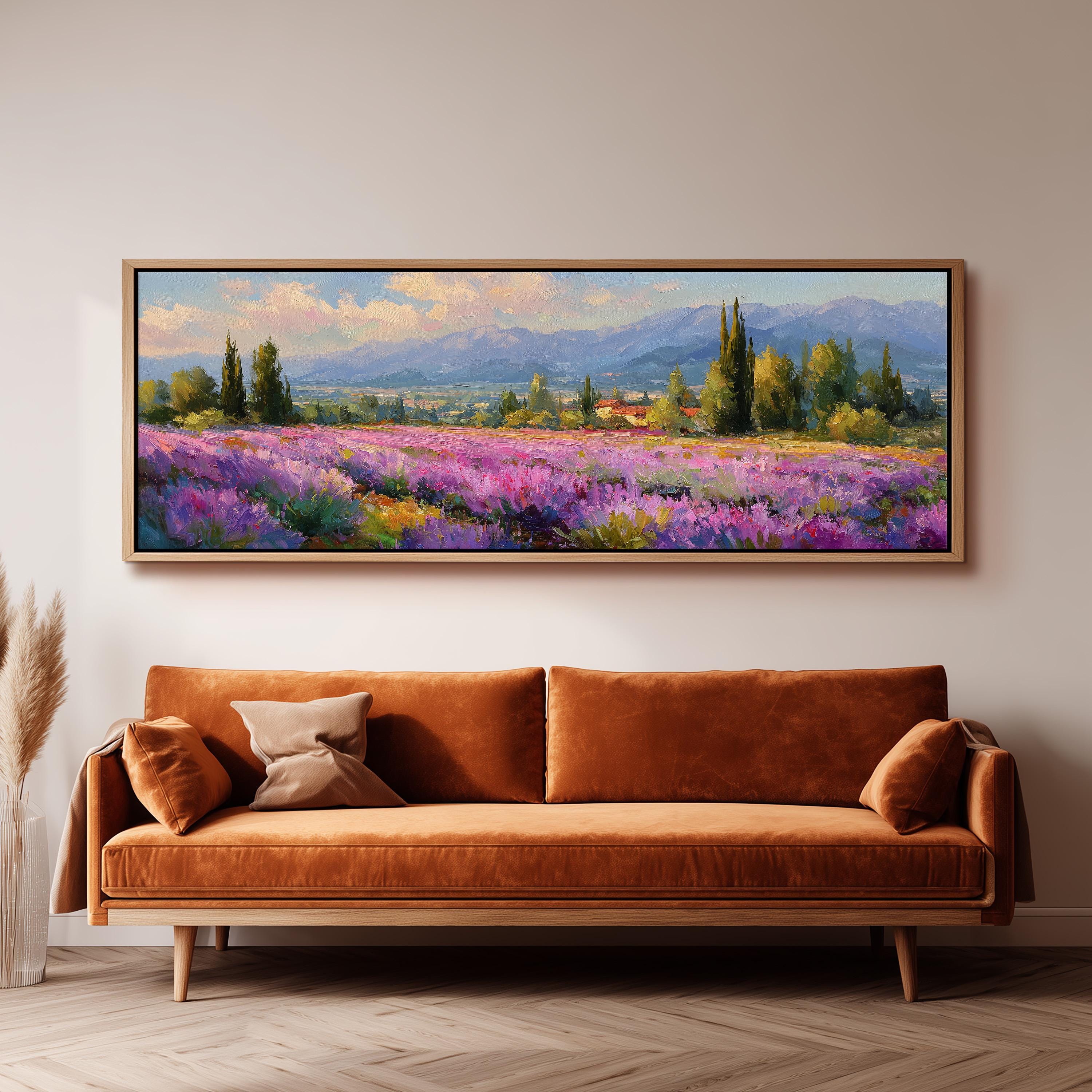 a large, framed painting of a field of purple flowers hanging on a wall above a brown sofa.