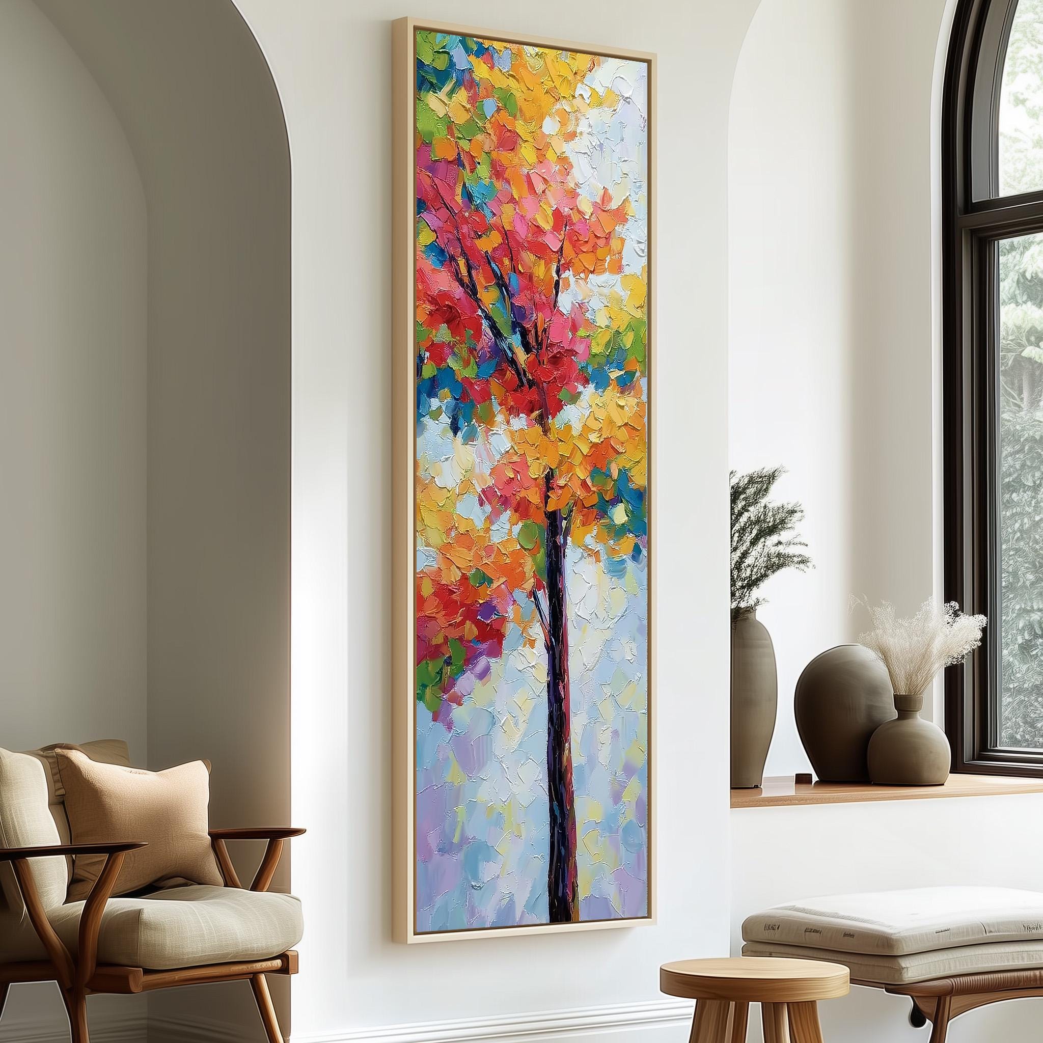 a large, colorful painting of a tree hanging on a wall in a room with a wooden chair and a small table.