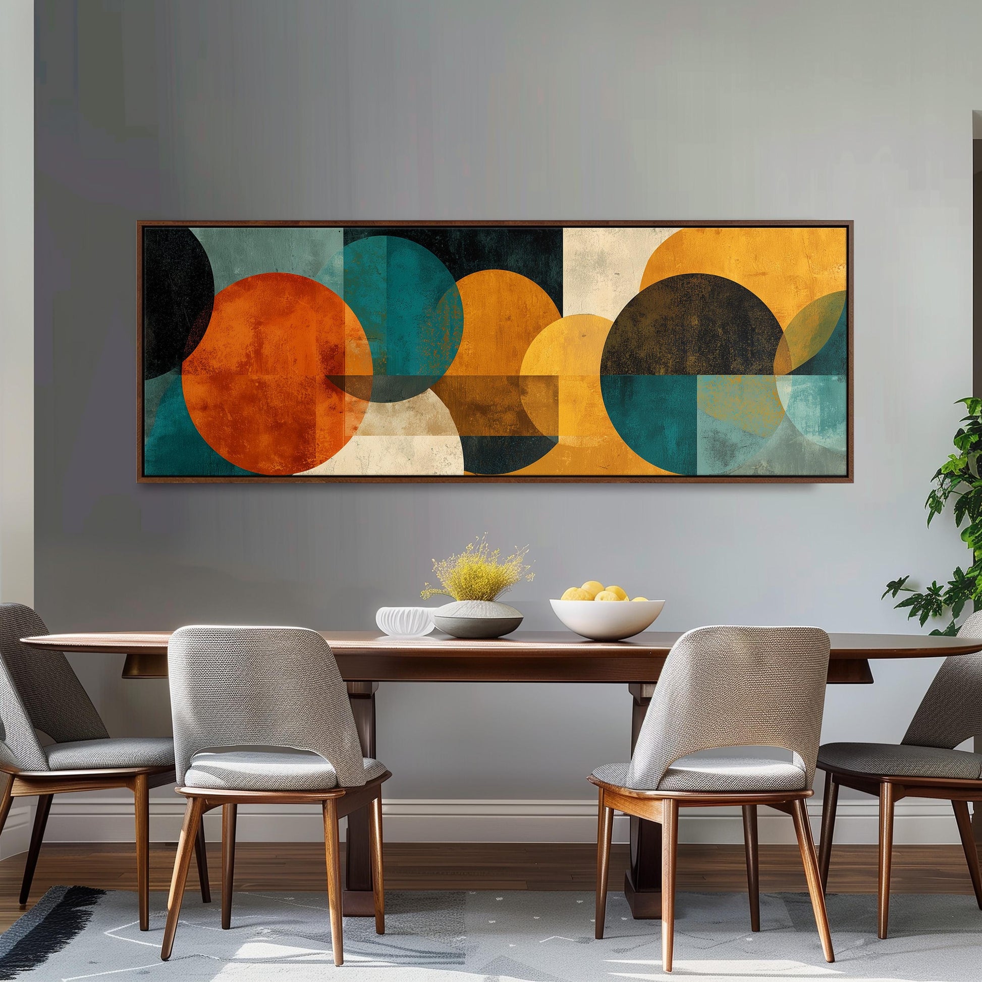 a modern dining room with a large abstract painting hanging on the wall above a wooden dining table. The table is set with a bowl of fruit and a vase of flowers, creating a welcoming and stylish atmosphere.