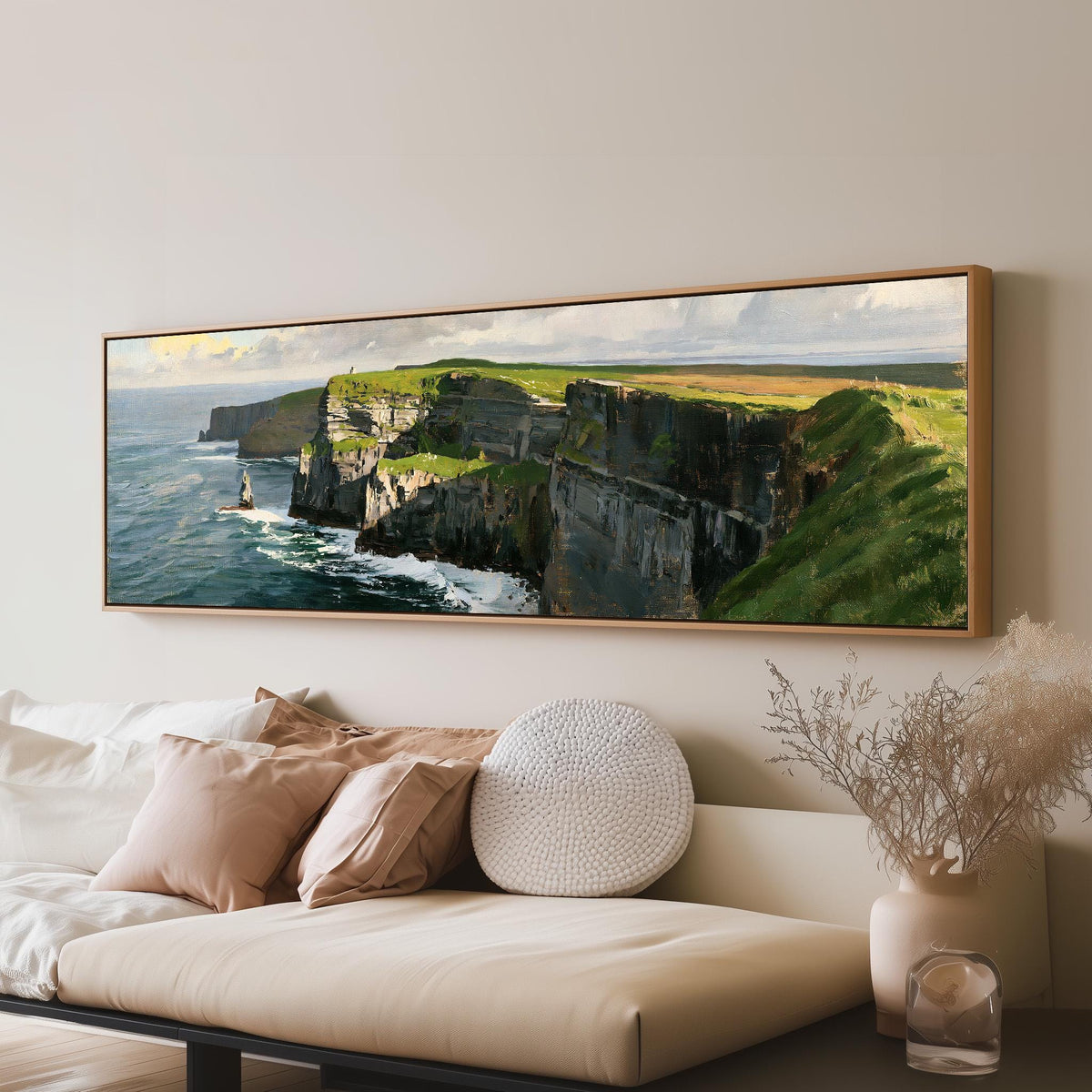 Sunlit sea cliffs with a sea stack long horizontal canvas print above a sofa in a living room