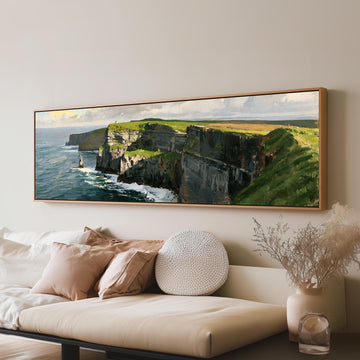 Sunlit sea cliffs with a sea stack long horizontal canvas print above a sofa in a living room