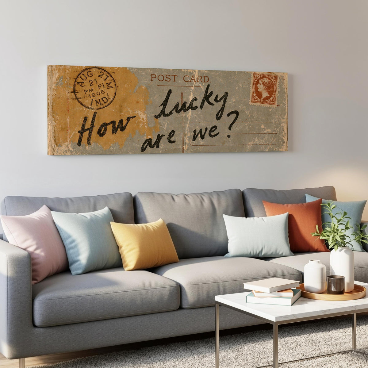 Vintage postcard saying how lucky are we panoramic canvas print above a grey sofa in a living room
