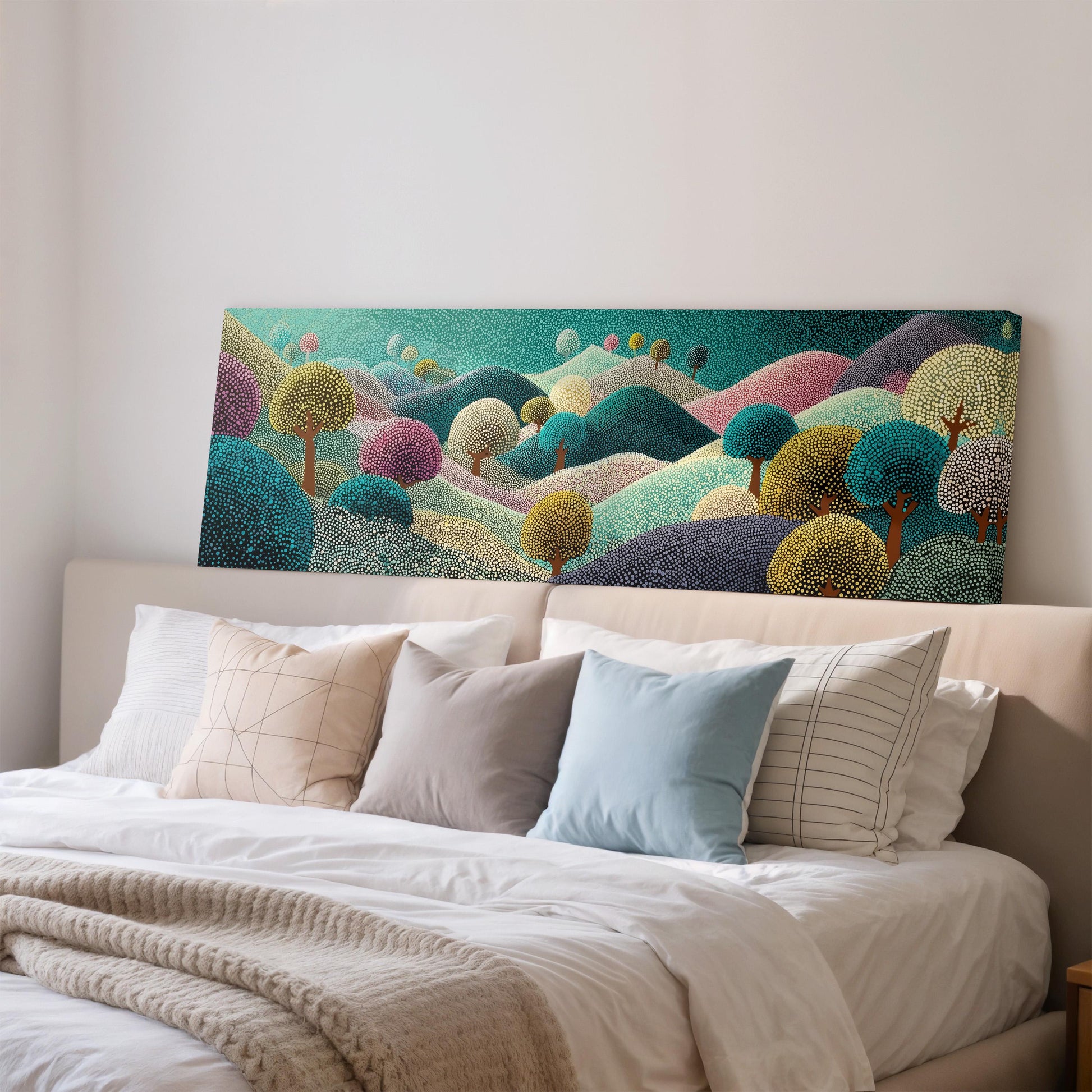 a large, colorful painting of a landscape hanging on a wall above a bed with white pillows and a gray blanket.