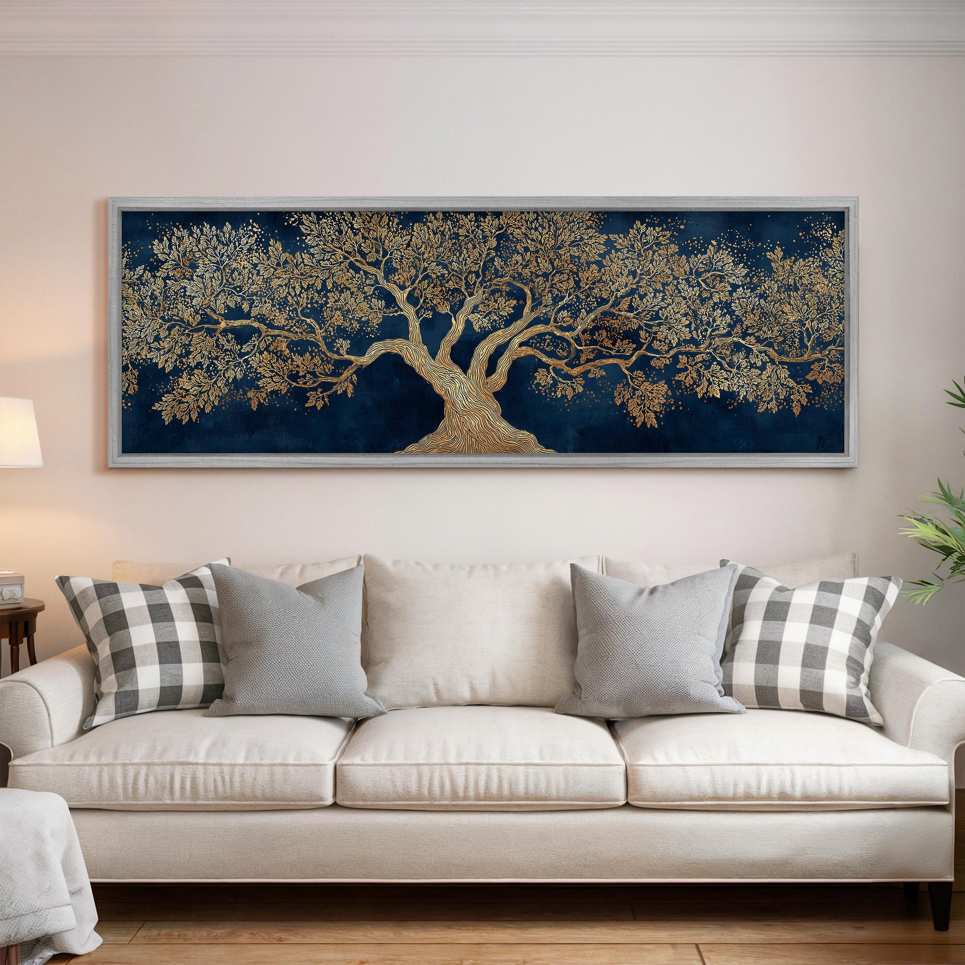 a large, ornate painting of a tree with a golden trunk and branches, hanging on a wall above a white sofa with gray and white patterned pillows.