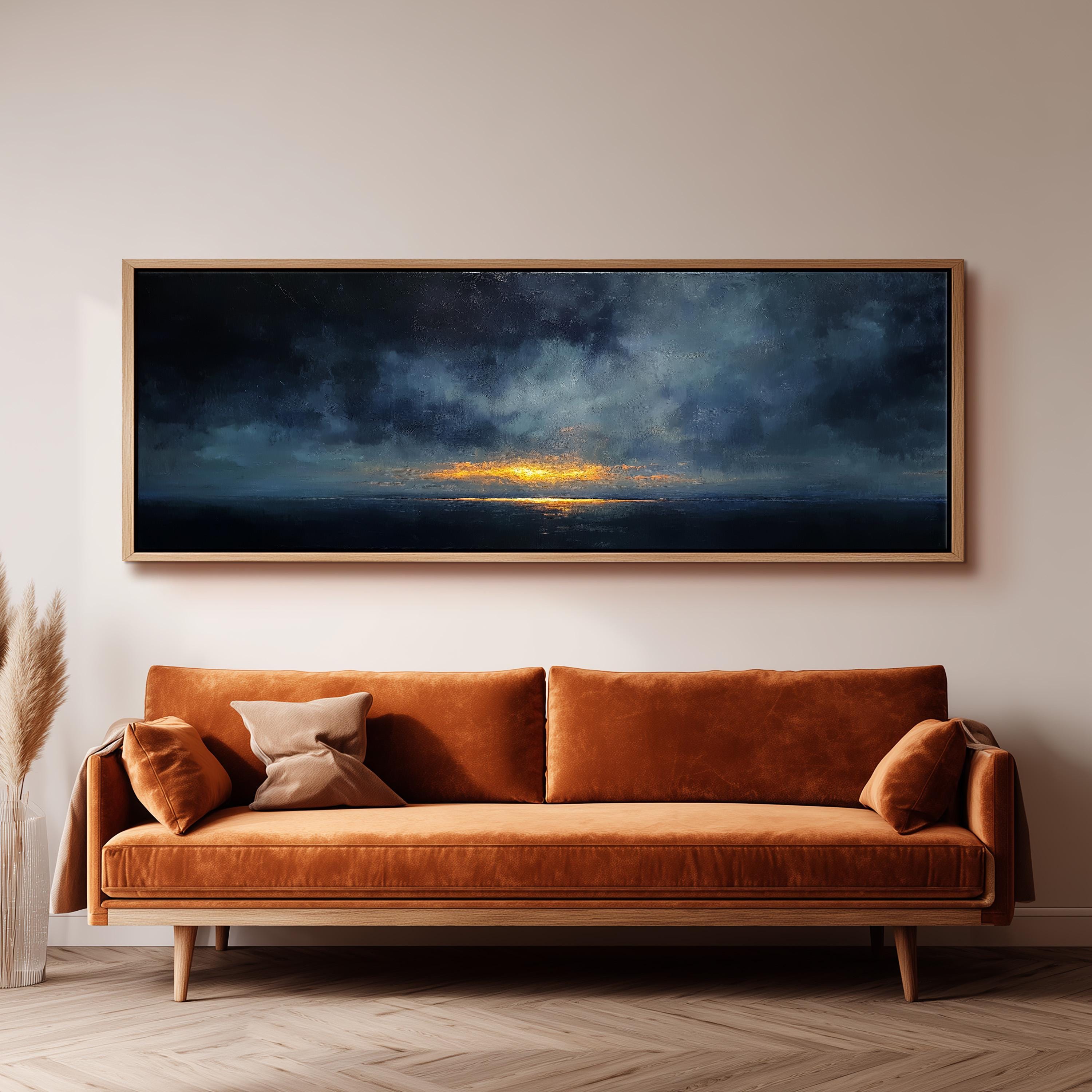 a large, rectangular painting hanging on a wall above a brown sofa with orange cushions.