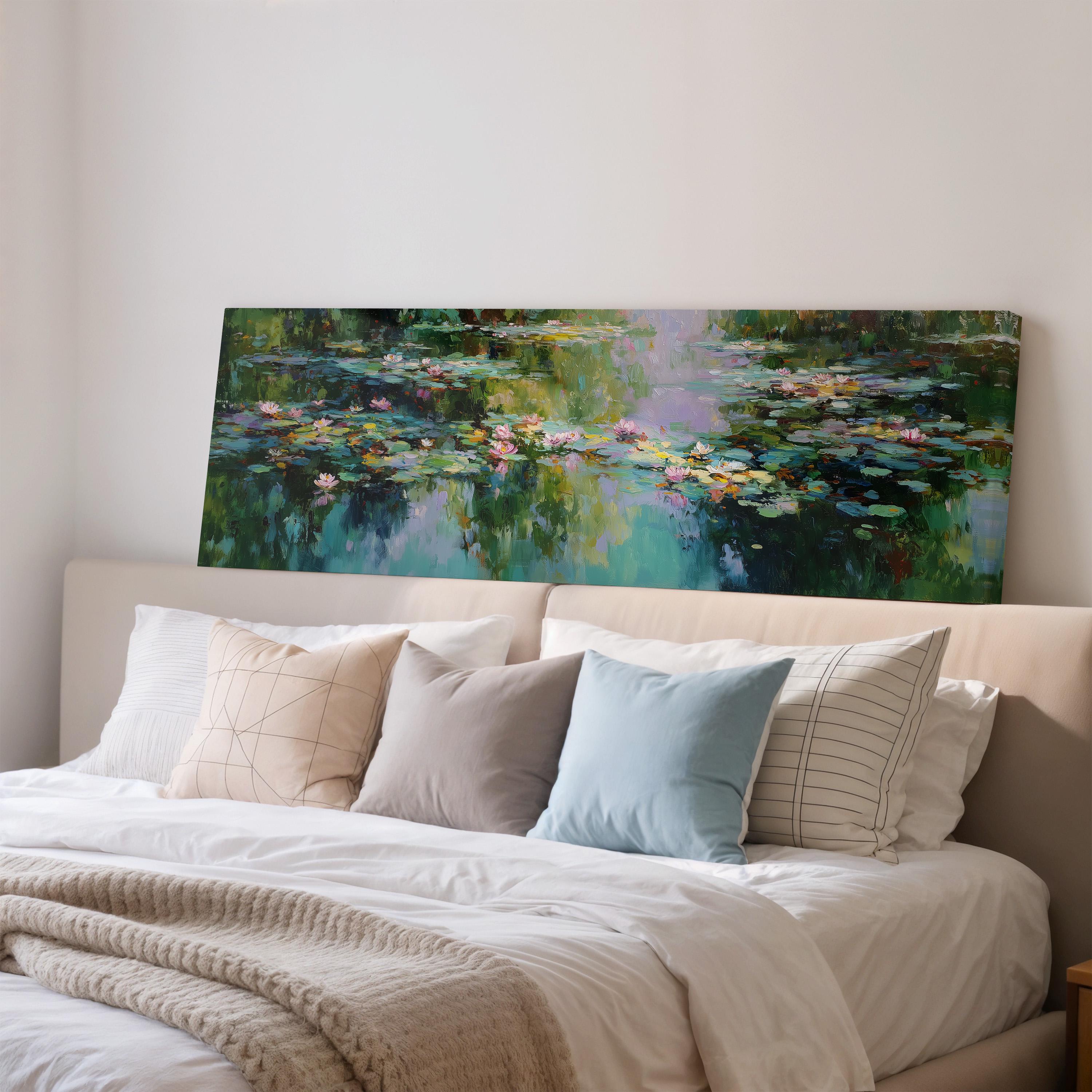 a large painting of a pond with lily pads hanging above a bed with white pillows and a gray blanket.