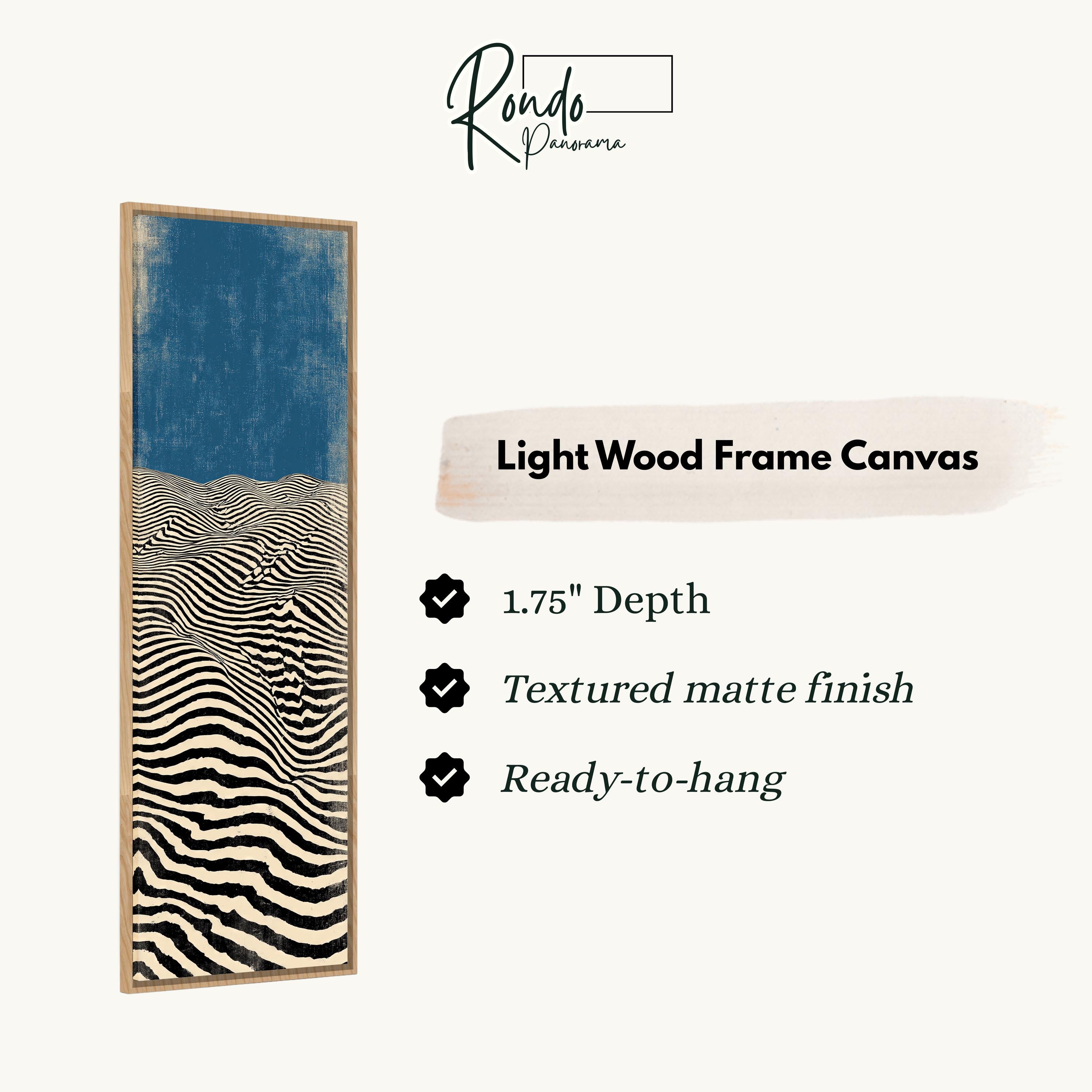 The image is a product description for a light wood frame canvas. It features a striking abstract artwork with a blue background and black and white stripes. The canvas has a 1.75" depth, a textured matte finish, and is ready to hang.