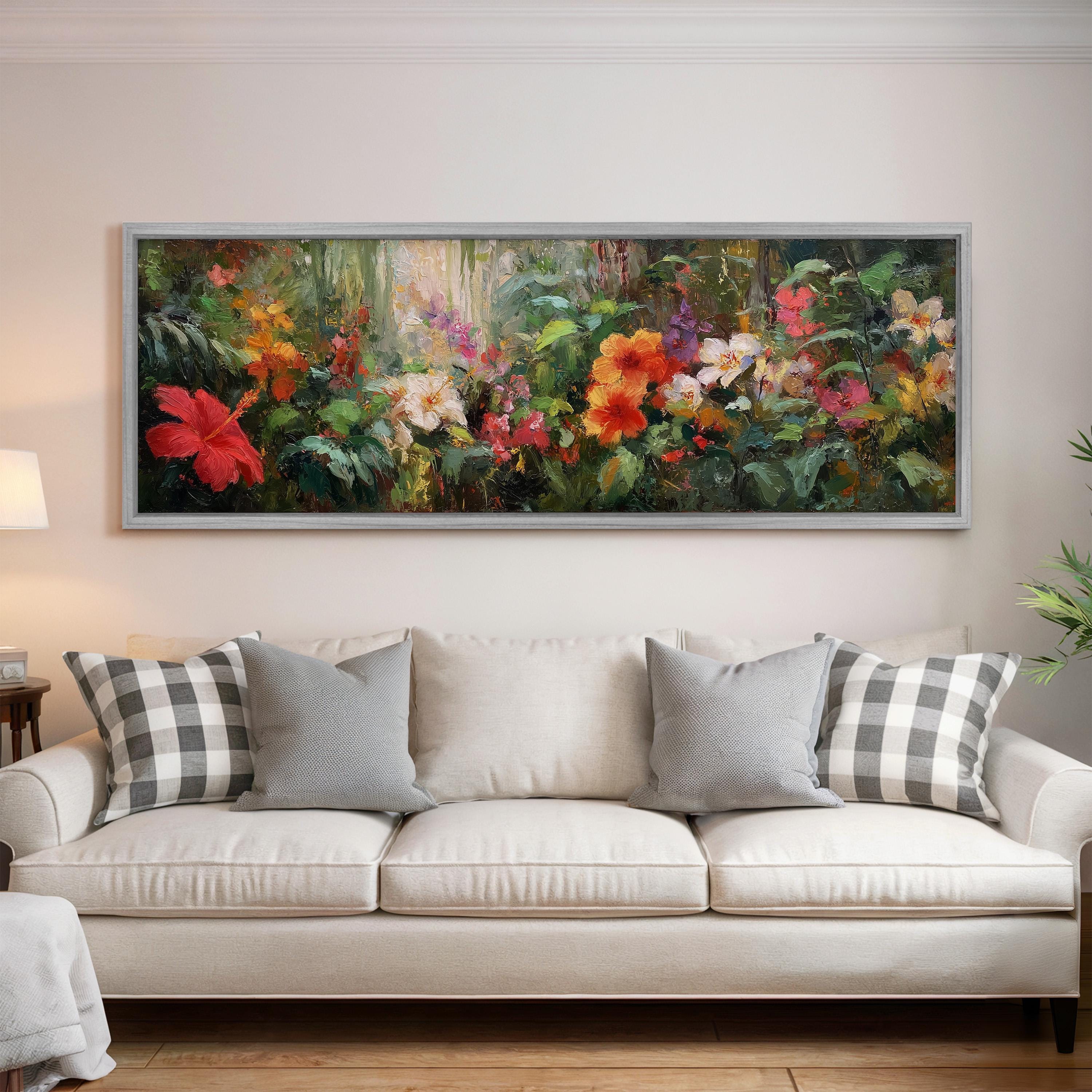 a large, colorful painting of flowers hanging on a wall above a white couch with gray and white patterned pillows.
