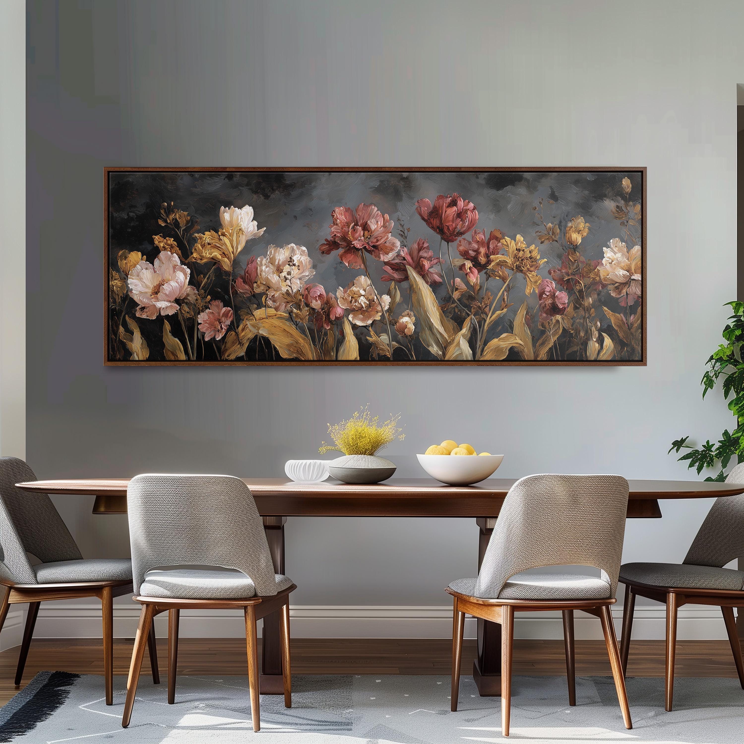 a dining room with a large painting of flowers hanging on the wall above a wooden table with four chairs. The table is set with a bowl of fruit and a vase of flowers, creating a cozy and inviting atmosphere.