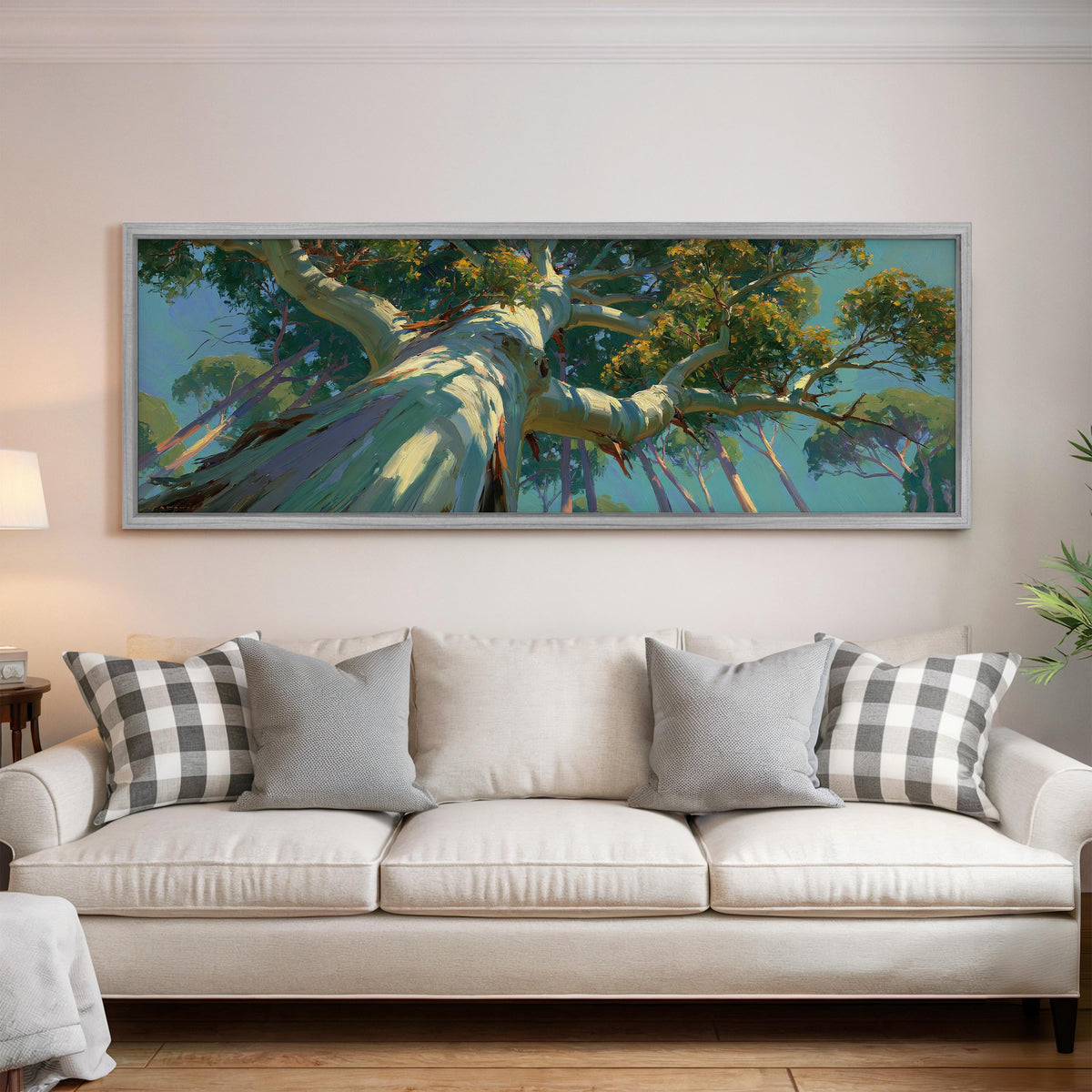 Eucalyptus canopy against a blue sky panoramic canvas print above a white sofa in a bright living room