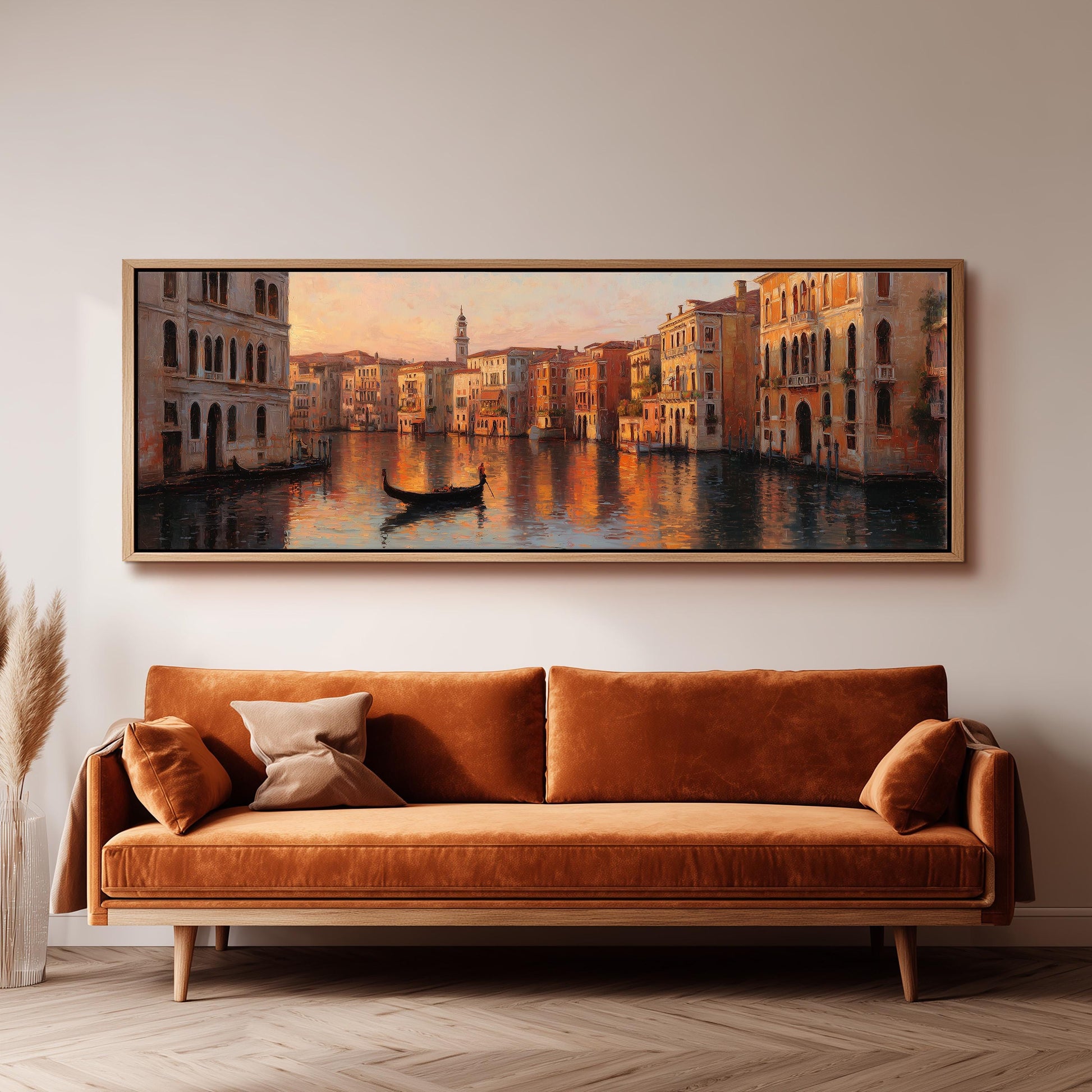 a large, framed painting of a picturesque Venetian canal scene, with a gondola floating on the water and colorful buildings lining the sides. The painting is hung on a wall above a brown sofa, creating a cozy and inviting atmosphere in the room.