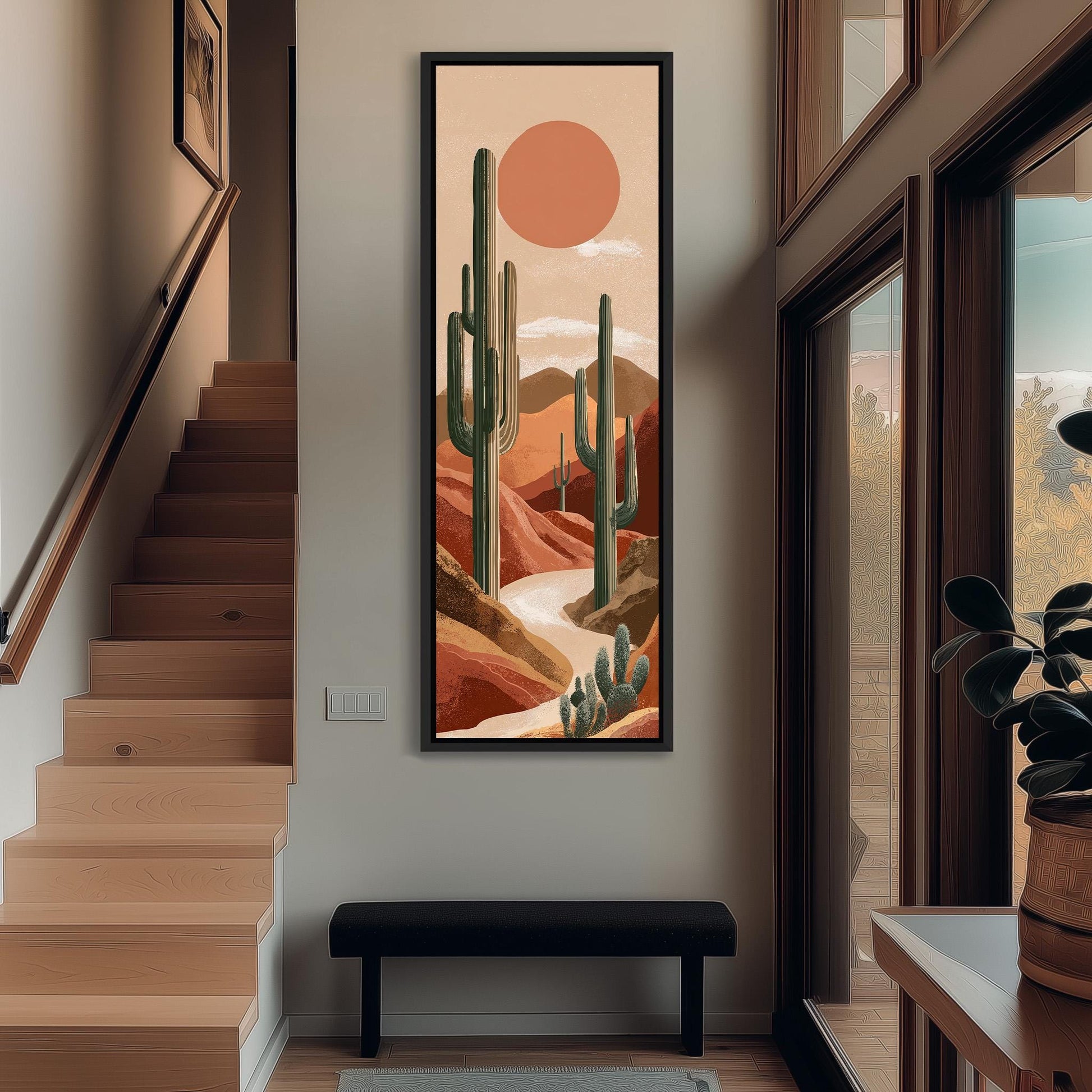 a large framed artwork depicting a desert landscape with cacti and mountains in the background, hanging on a wall in a hallway.