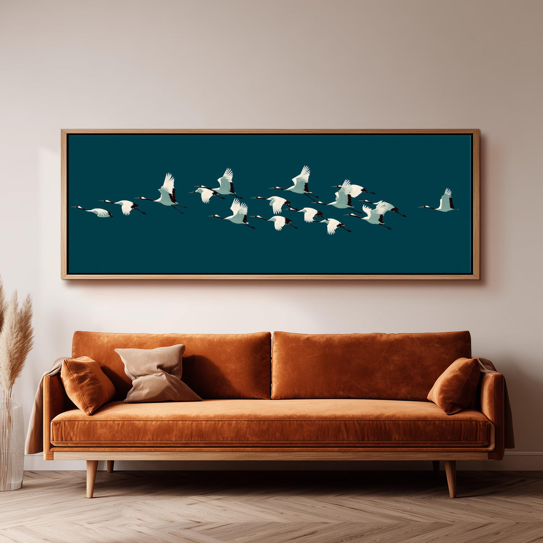 a large canvas print of a flock of white birds flying over a dark blue background, mounted on a wall above a bed with white pillows and a gray blanket.