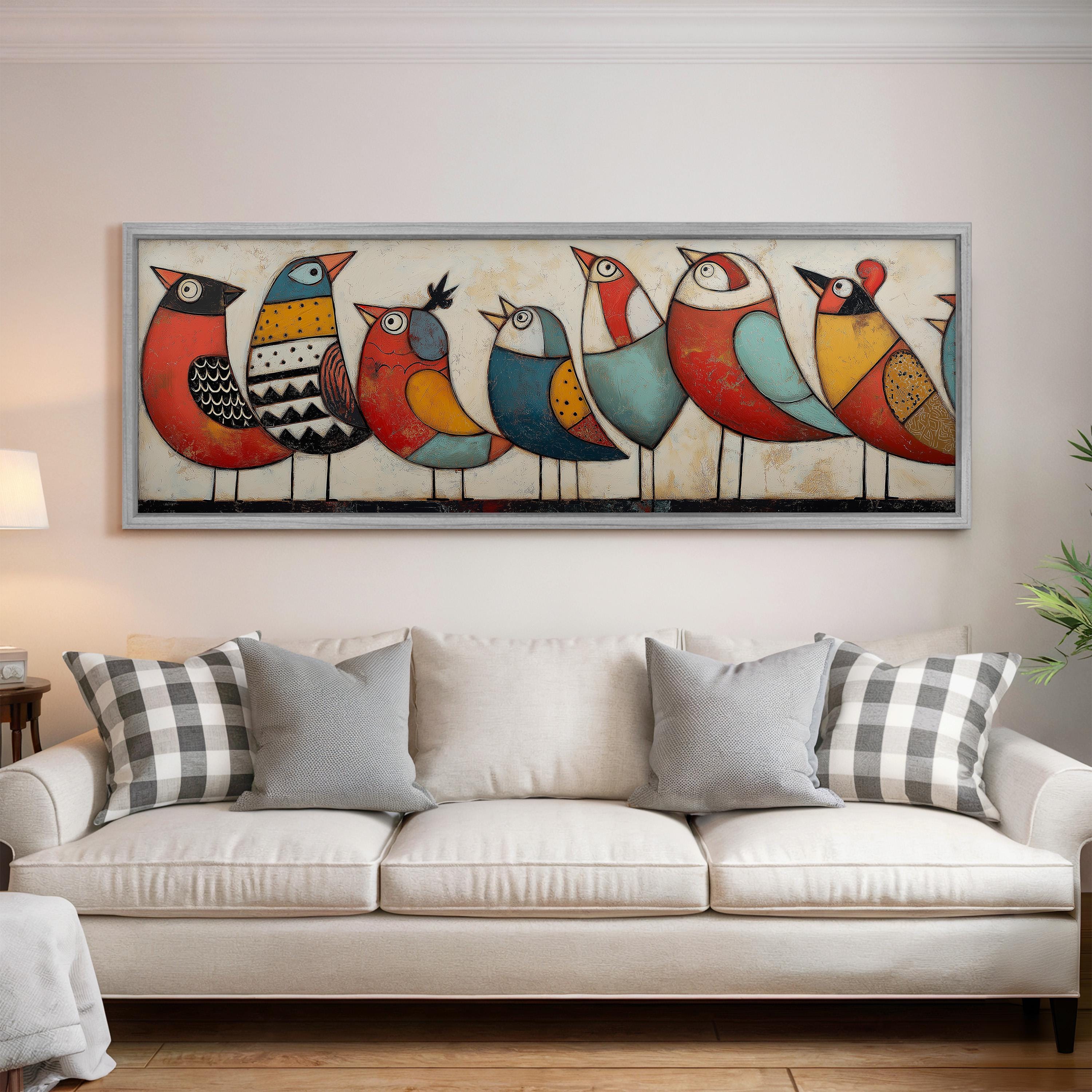 a large, colorful painting of nine birds on a white wall above a white couch with gray and white plaid throw pillows.