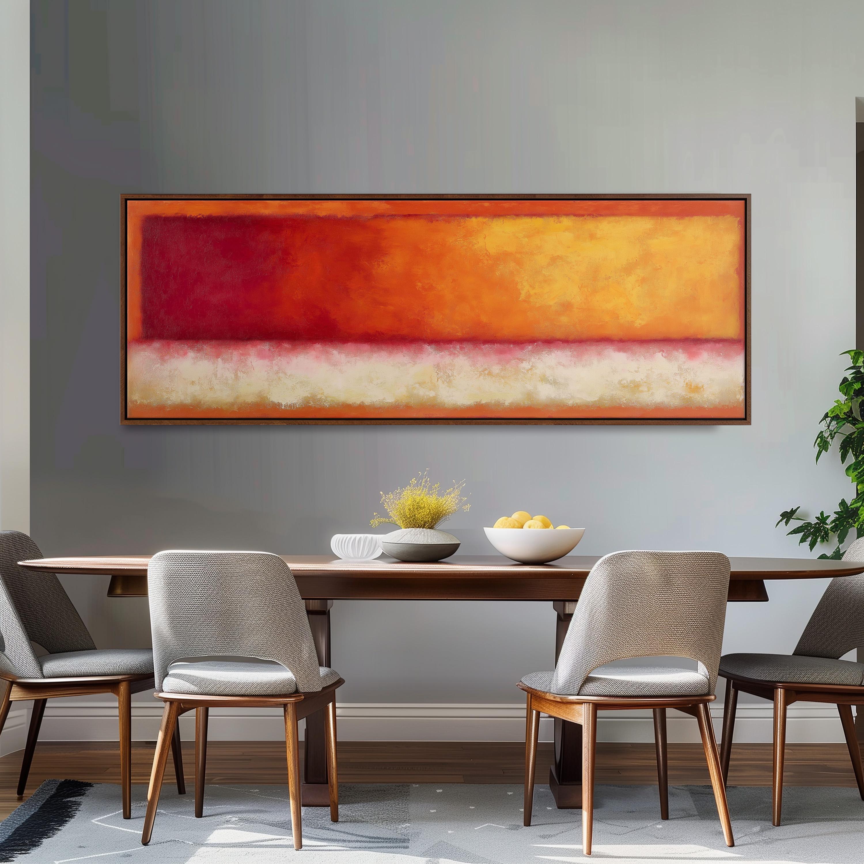 a dining room with a wooden table and four chairs. Above the table, there is a large painting with a warm color palette of red, orange, and yellow. The painting is framed and hangs on the wall above the table. On the table, there is a bowl of fruit and a vase of flowers, adding a touch of elegance to the setting.