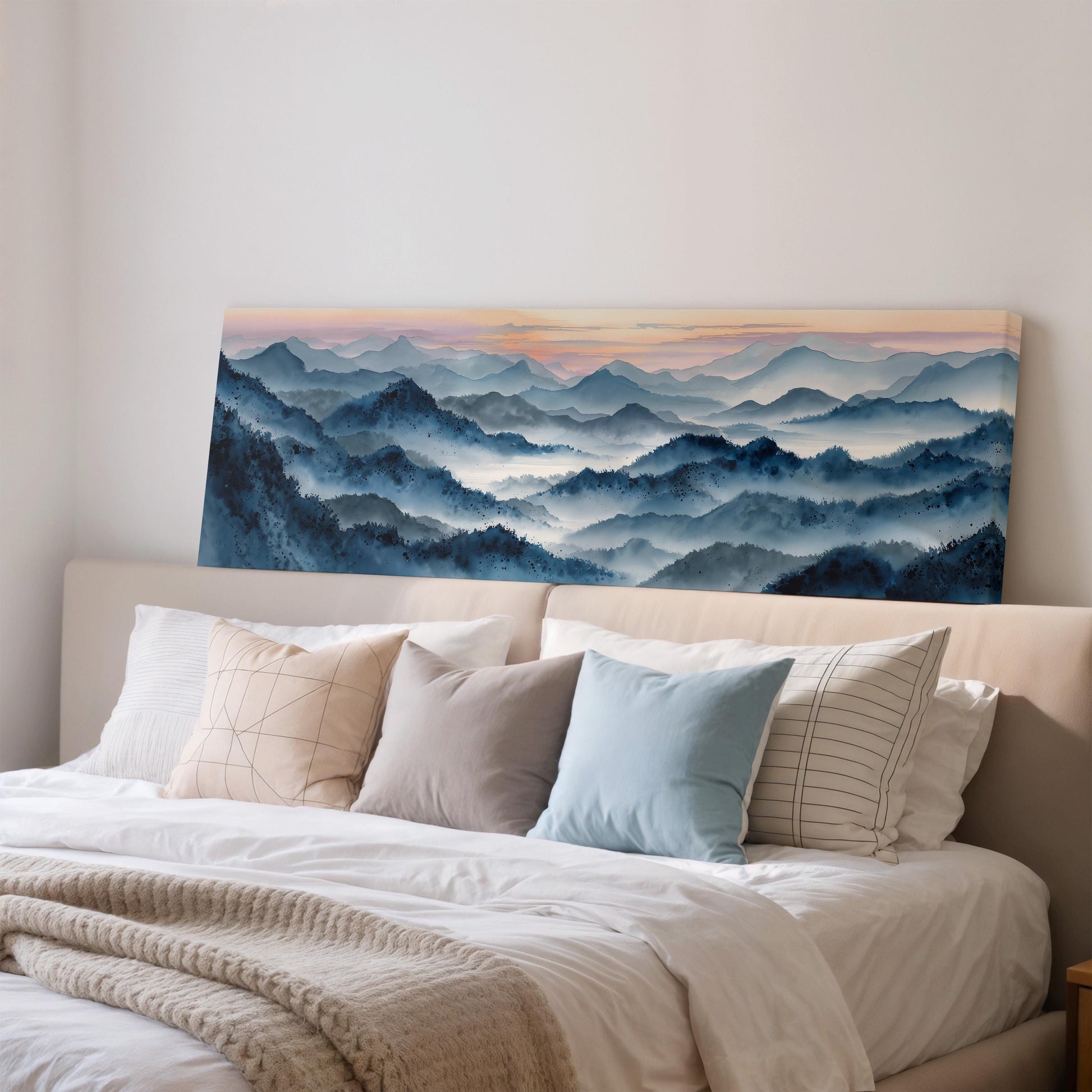 a large painting of a mountain landscape hanging on a wall above a bed with white bedding and pillows.
