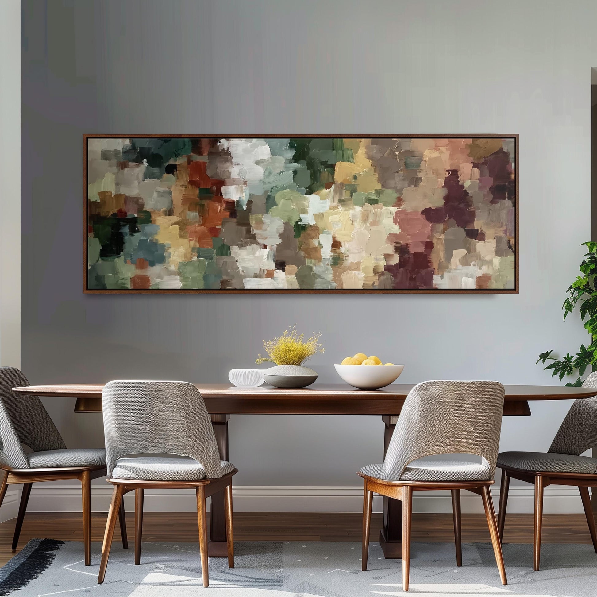 a dining room with a large abstract painting hanging on the wall above a wooden table with four chairs. The table is set with a bowl of fruit and a vase of flowers, creating a cozy and inviting atmosphere.