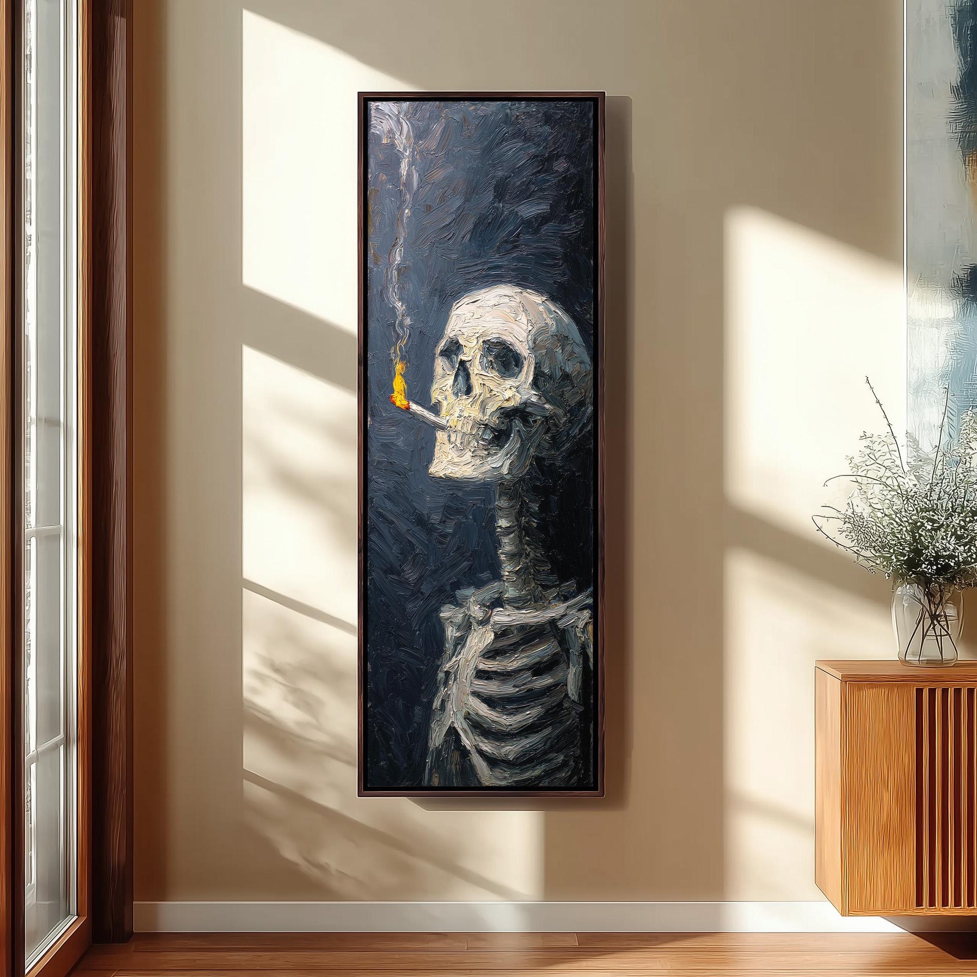 a large painting of a skeleton with a lit cigarette in its mouth, hanging on a wall in a room with a wooden cabinet and a vase of flowers.