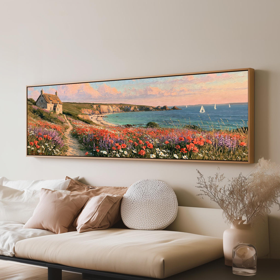 Seaside cottage above a poppy-covered cliff path long horizontal canvas print above a sofa in a living room