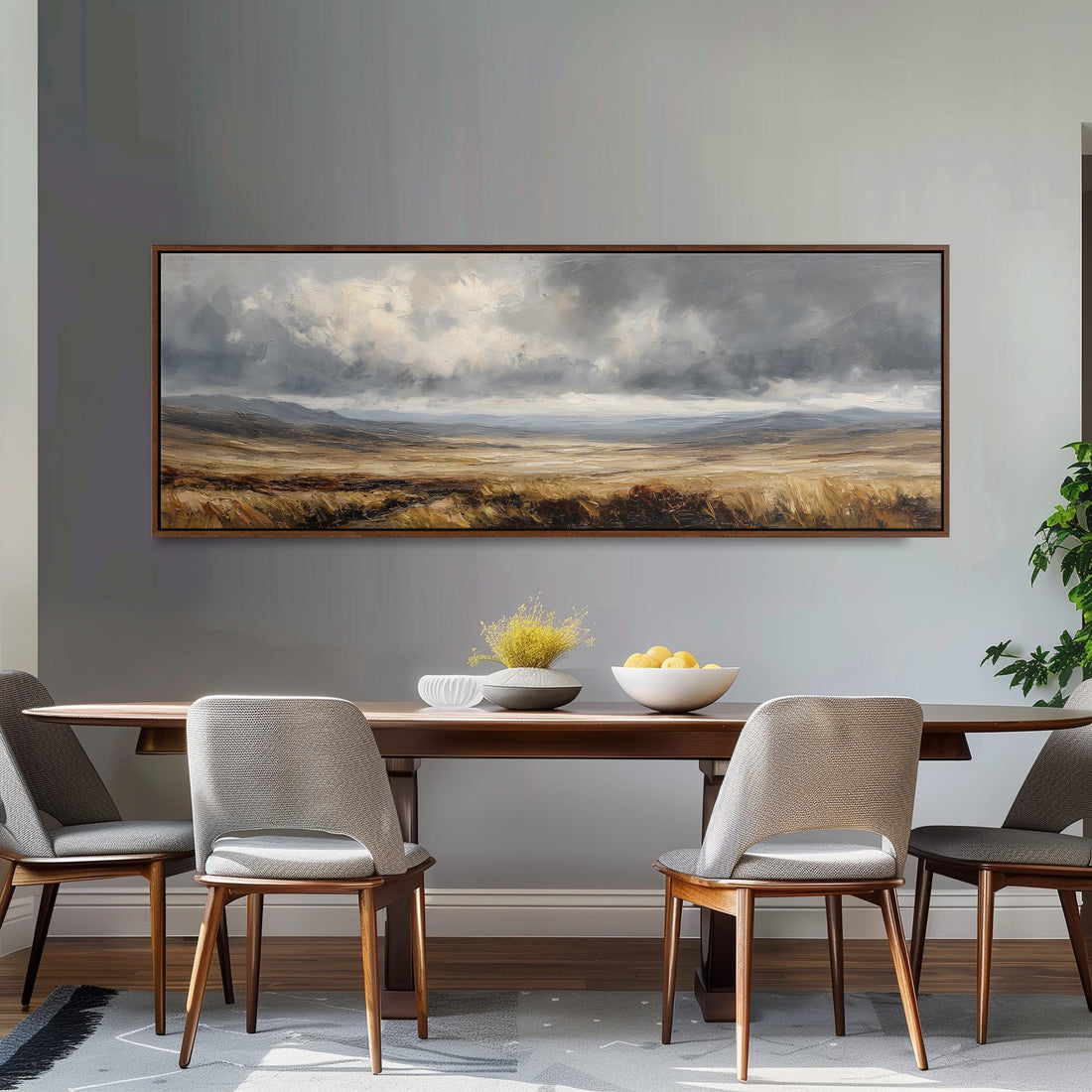 a dining room with a large landscape painting hanging on the wall above a wooden table with four chairs. The painting depicts a cloudy sky over a field, creating a serene and peaceful atmosphere.