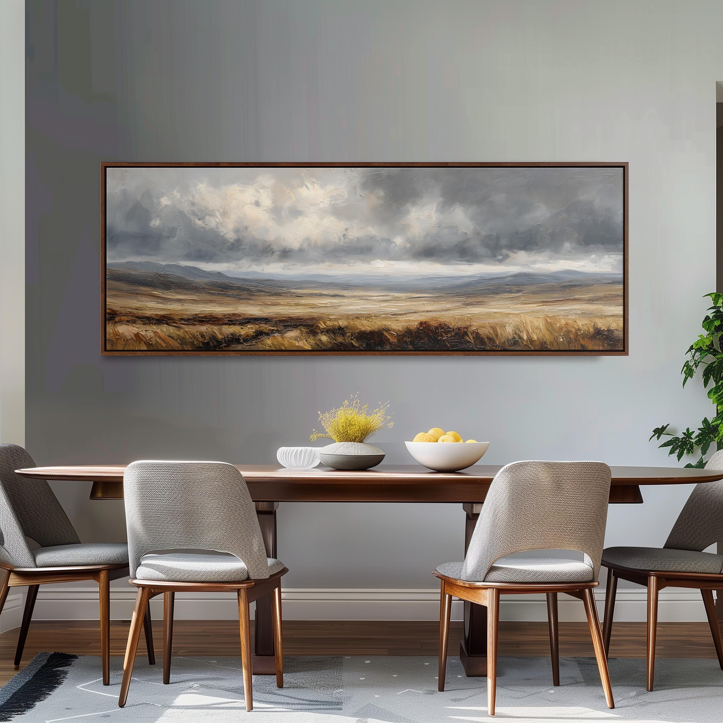 a dining room with a large landscape painting hanging on the wall above a wooden table with four chairs. The painting depicts a cloudy sky over a field, creating a serene and peaceful atmosphere.