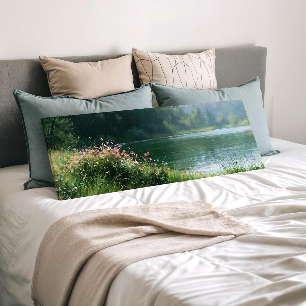 Pink wildflowers on a green lakeshore wide panoramic canvas print laid on a bed to show its size