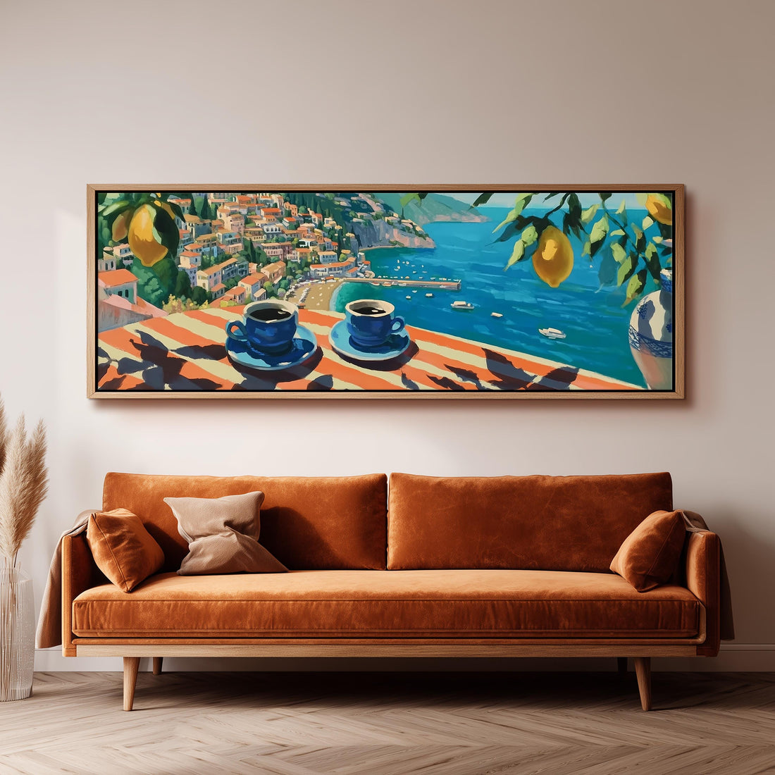 a large painting of a coastal town with a view of the sea, hanging on a wall above a brown sofa with two pillows.