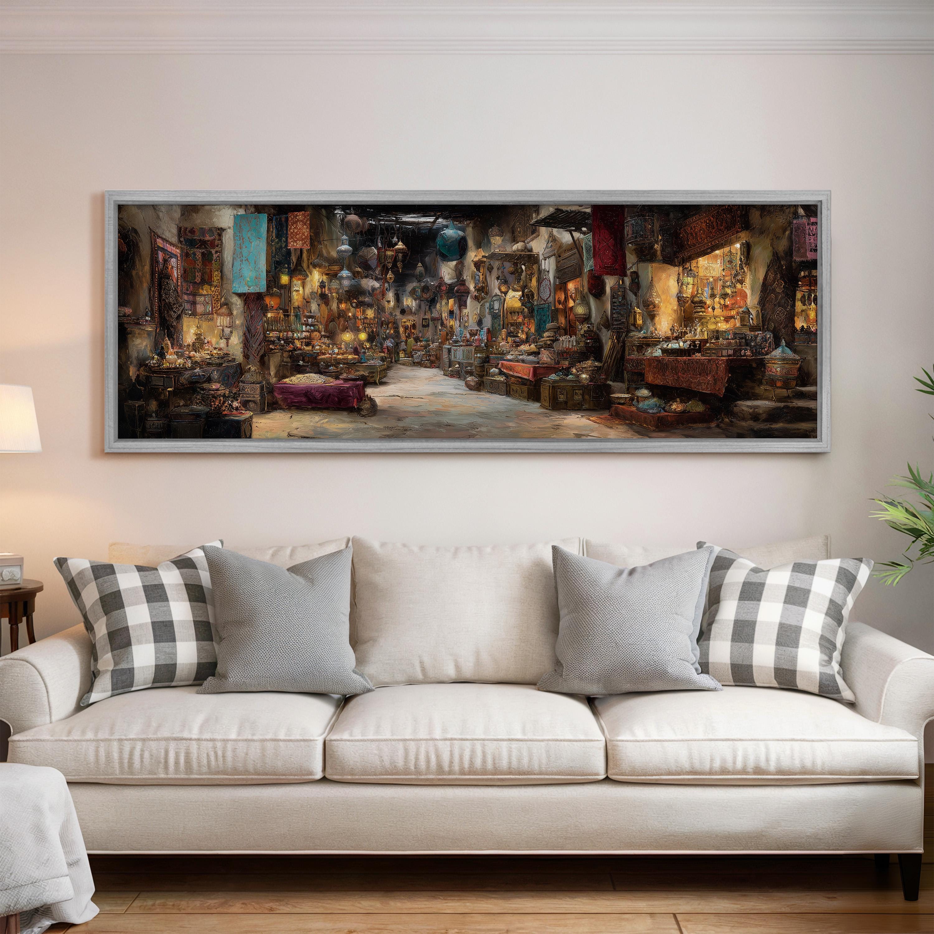 a large, colorful painting of a bustling market scene hanging on a wall above a white couch with patterned throw pillows.