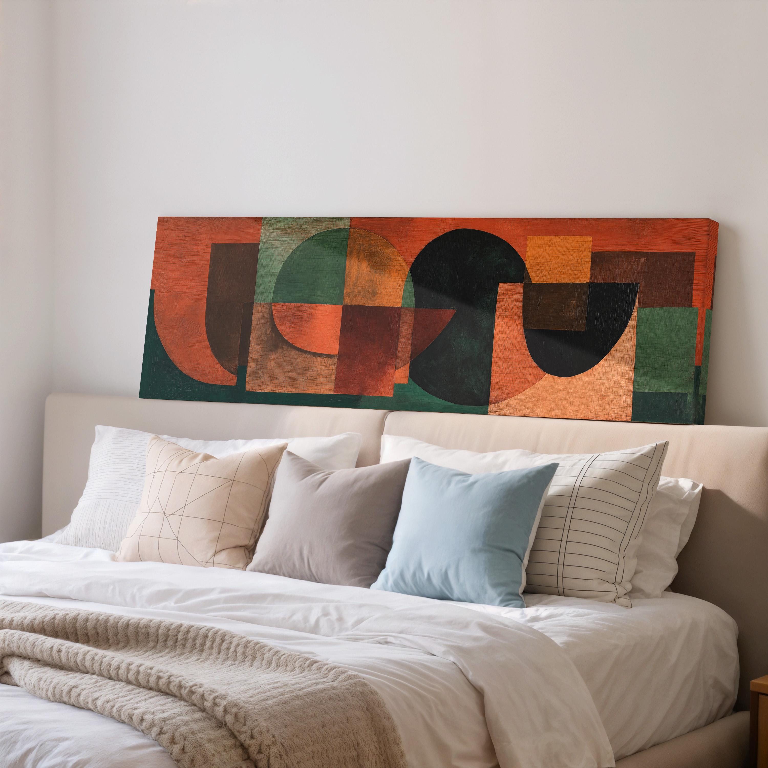 a large abstract painting hanging on a wall above a bed with white pillows and a gray blanket.