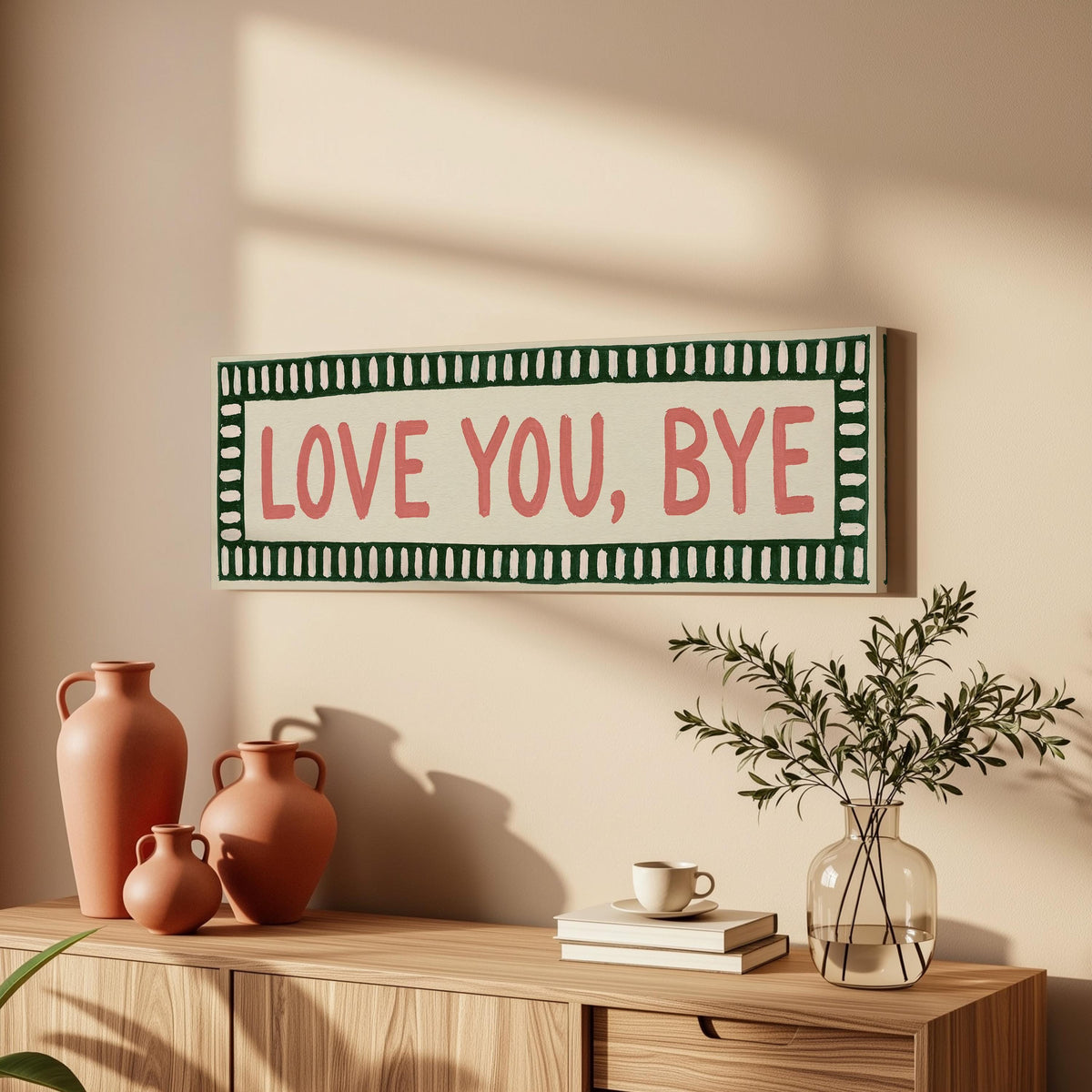 Love you, bye sign with a green border long horizontal canvas print above a wooden sideboard