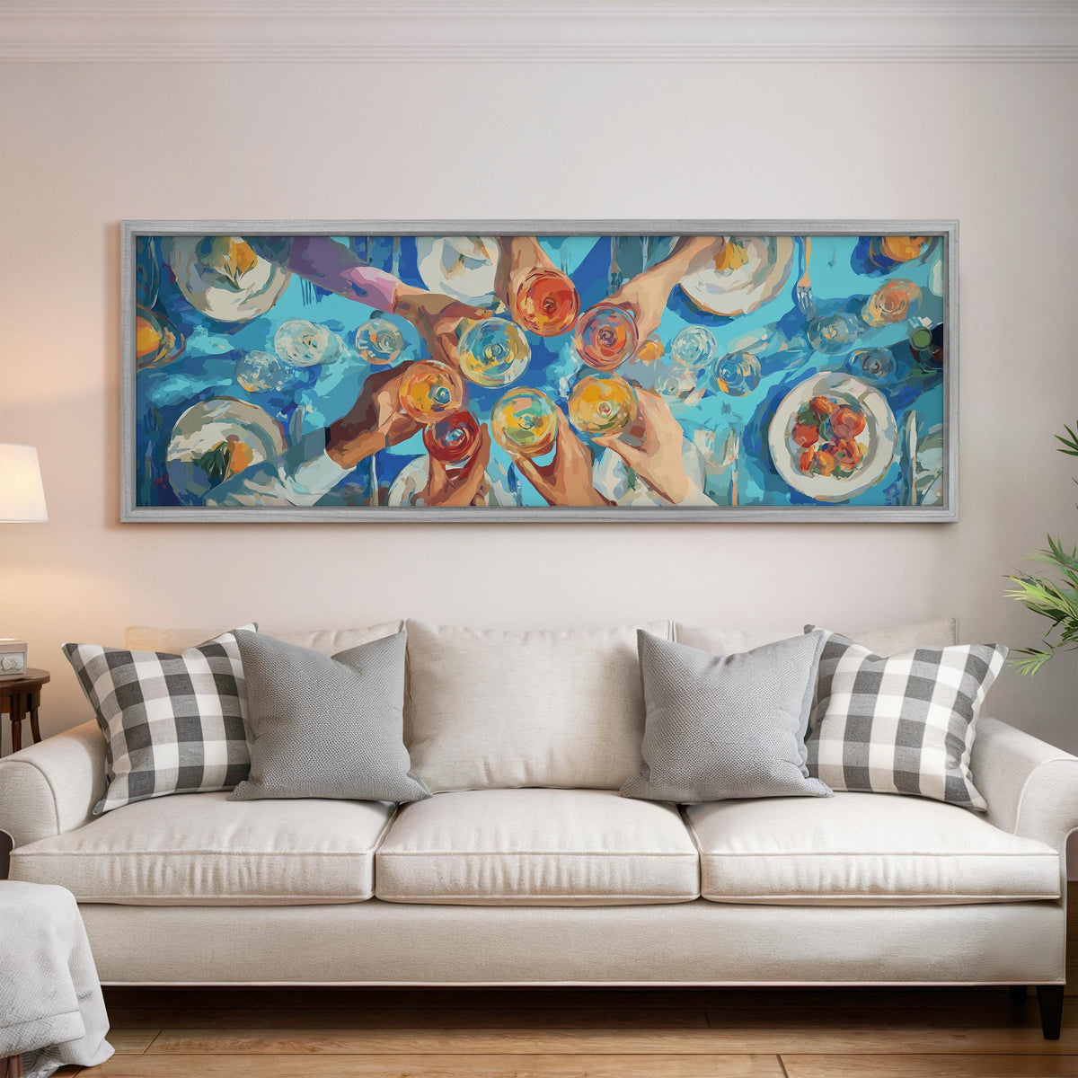 Friends toasting over a blue table from above panoramic canvas print above a white sofa in a bright living room