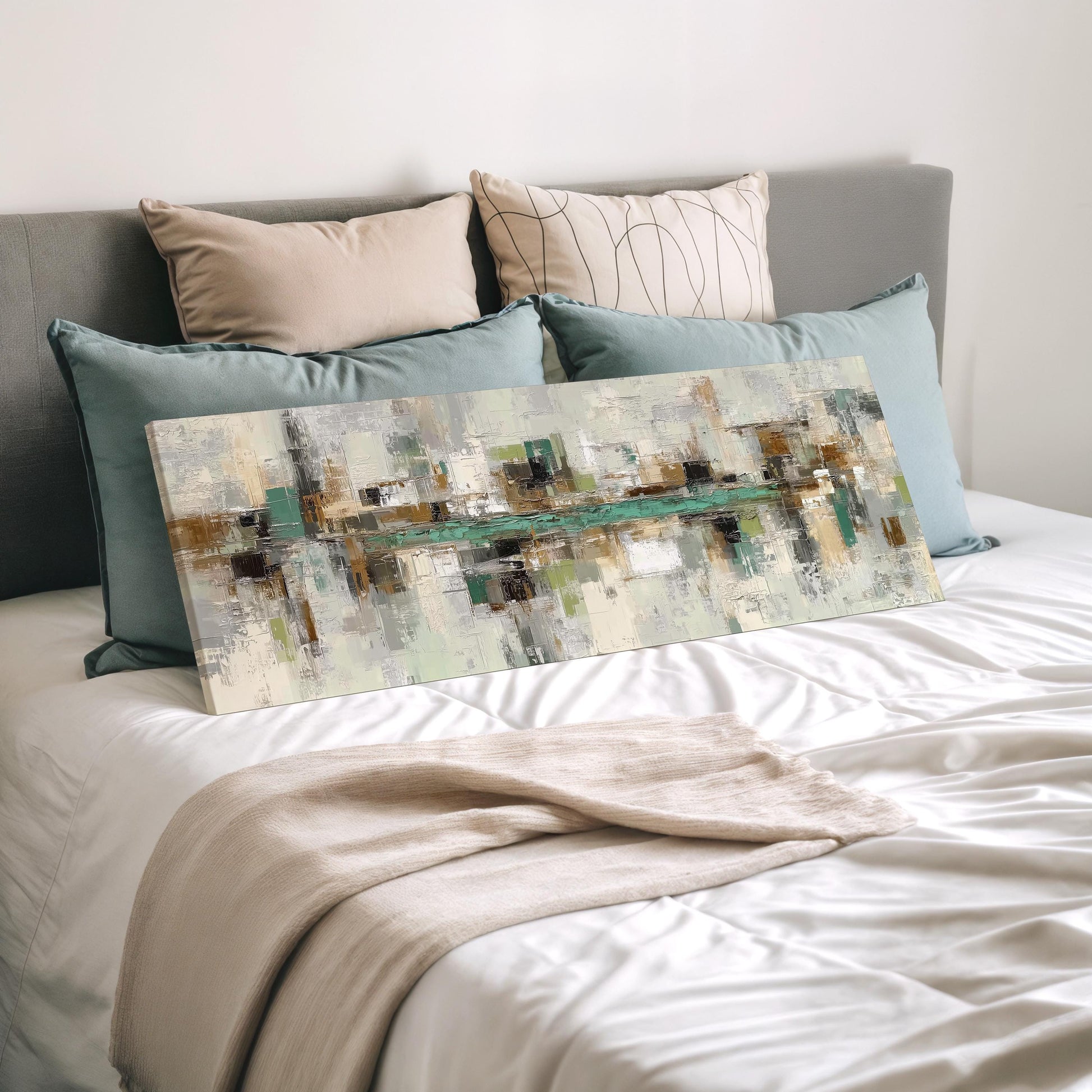 a bedroom with a large abstract painting on the bed, surrounded by various pillows and a white comforter.