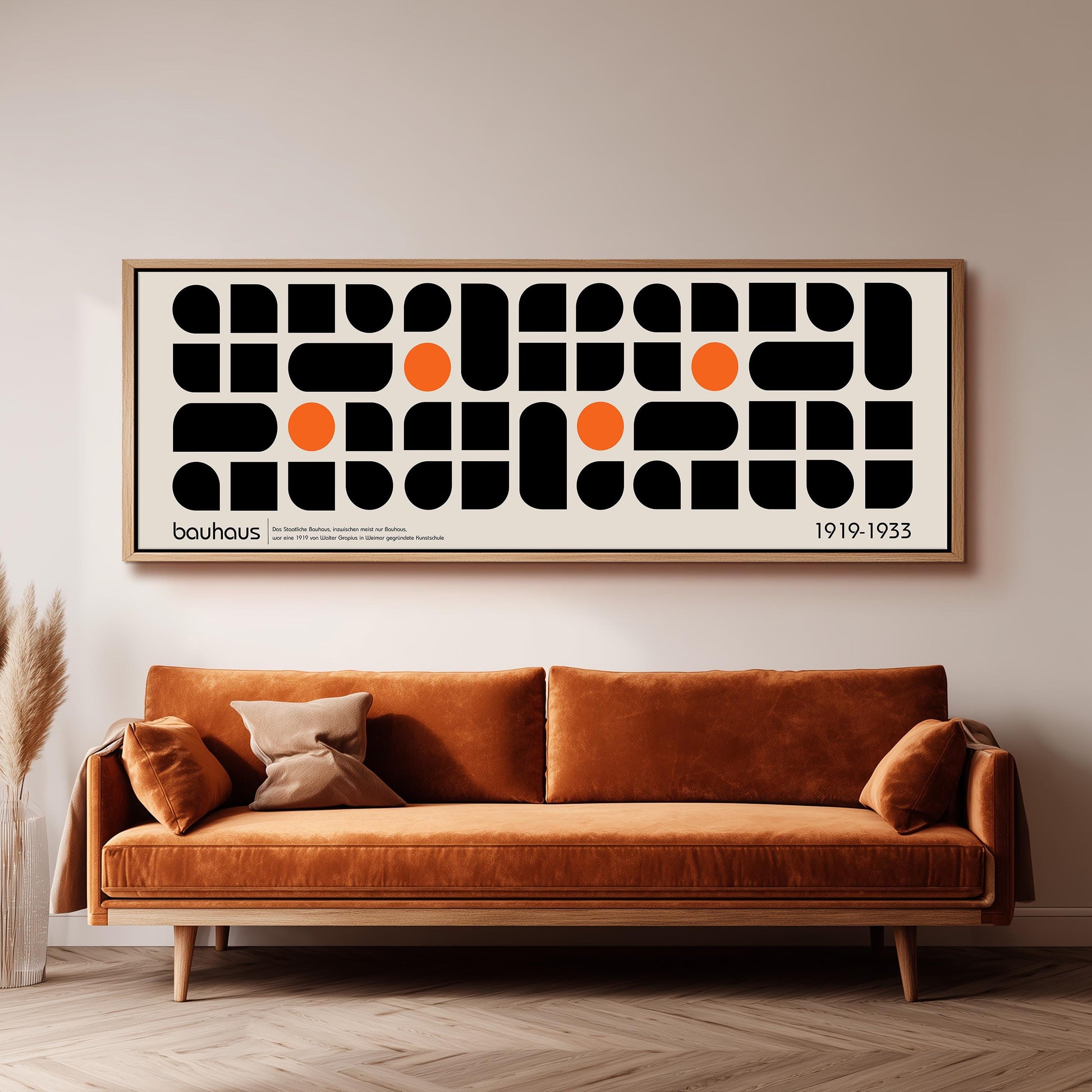 a large abstract art piece hanging on a wall above a brown sofa in a living room setting.