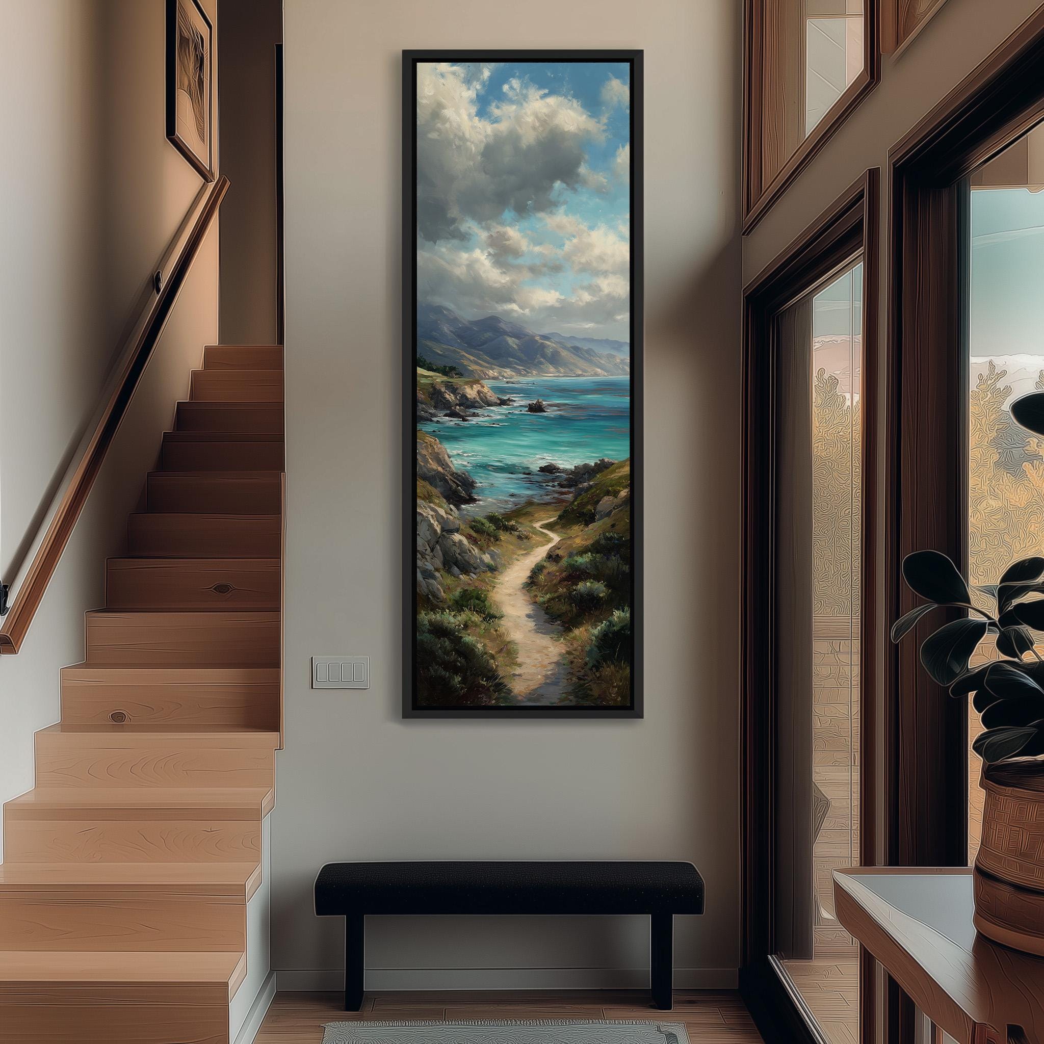a large painting of a coastal landscape hanging on the wall of a hallway. The painting depicts a winding path leading to a serene body of water, surrounded by mountains and lush greenery. The hallway is well-lit, with a wooden staircase and a bench in the foreground. The painting adds a sense of tranquility and natural beauty to the space.