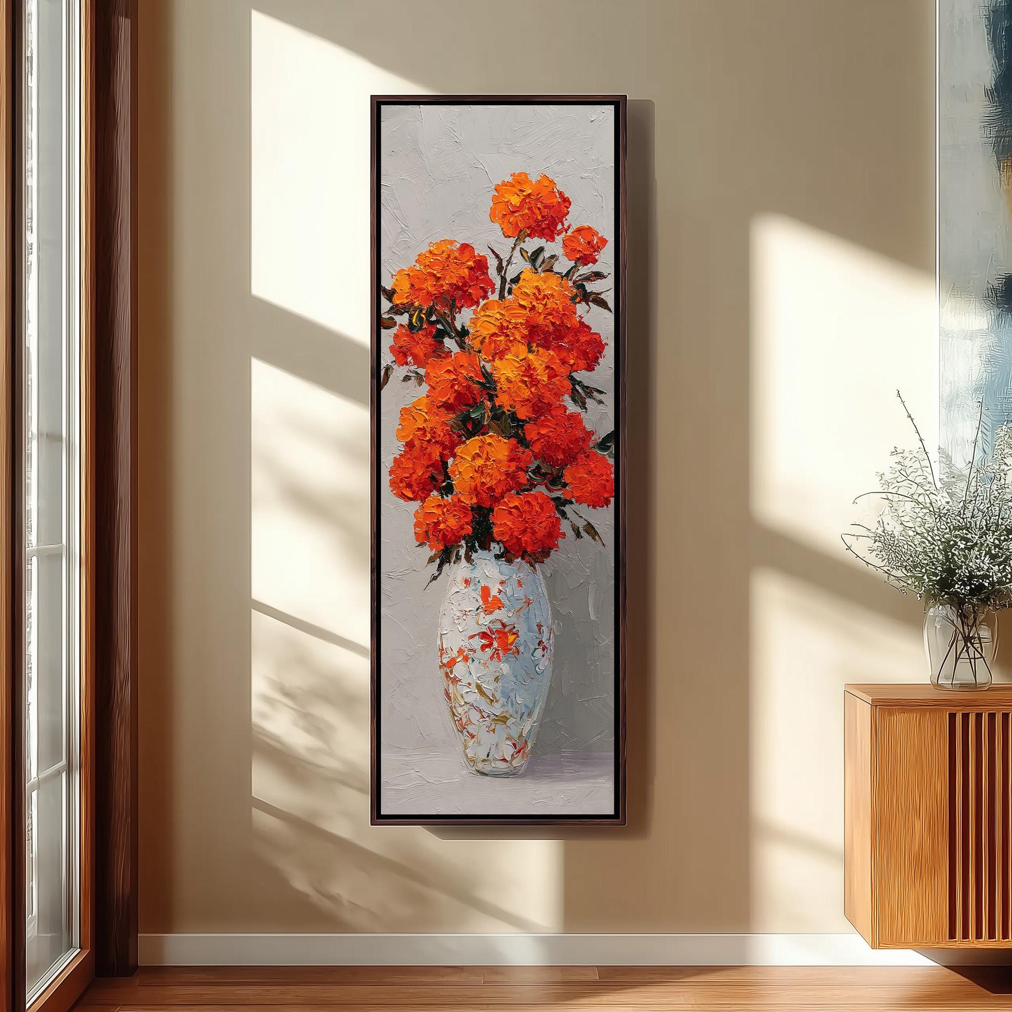 a large, vibrant painting of a vase filled with orange flowers, hanging on a wall in a room with a wooden cabinet and a window.