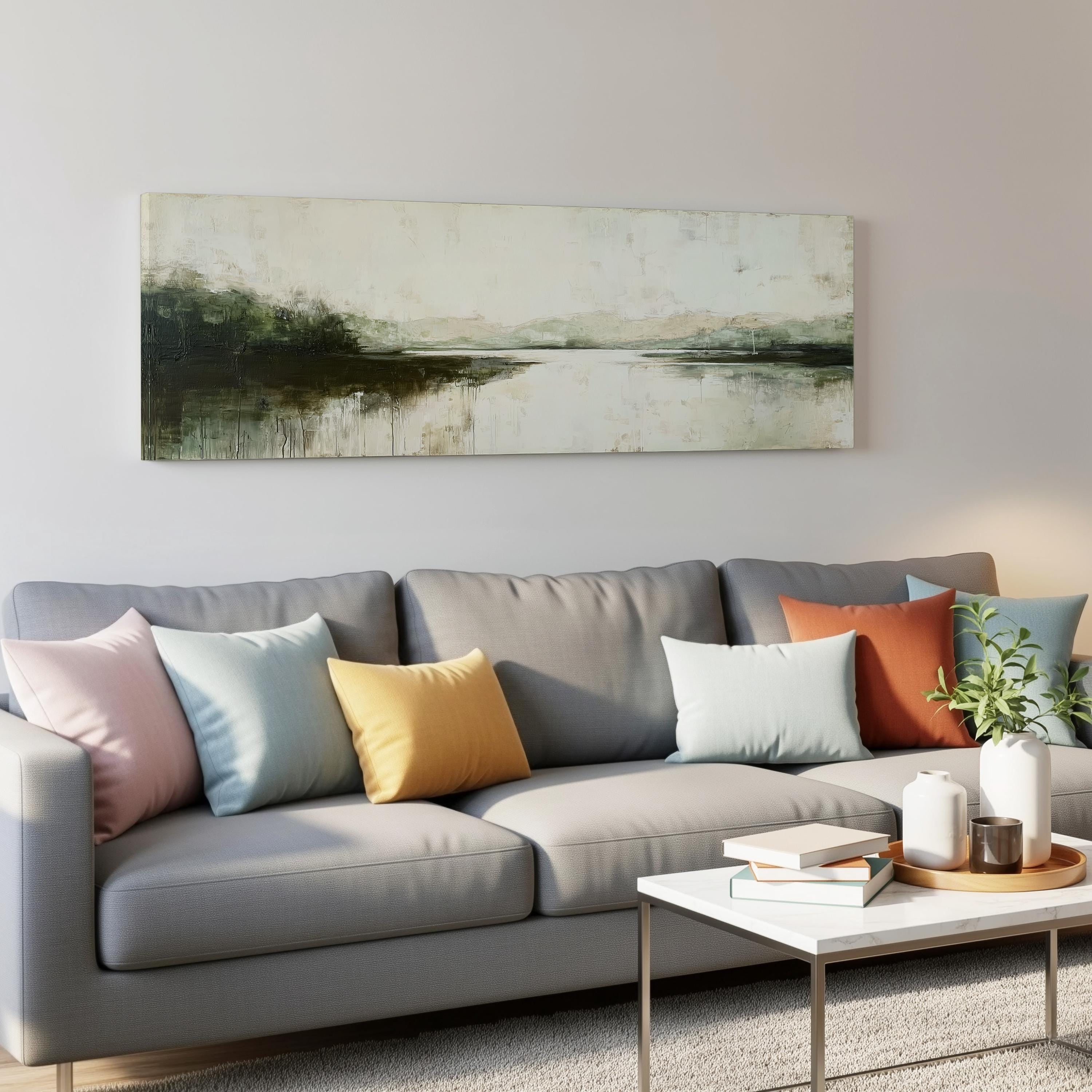 a modern living room with a gray sofa adorned with colorful throw pillows, a white coffee table, and a painting hanging on the wall above the sofa.