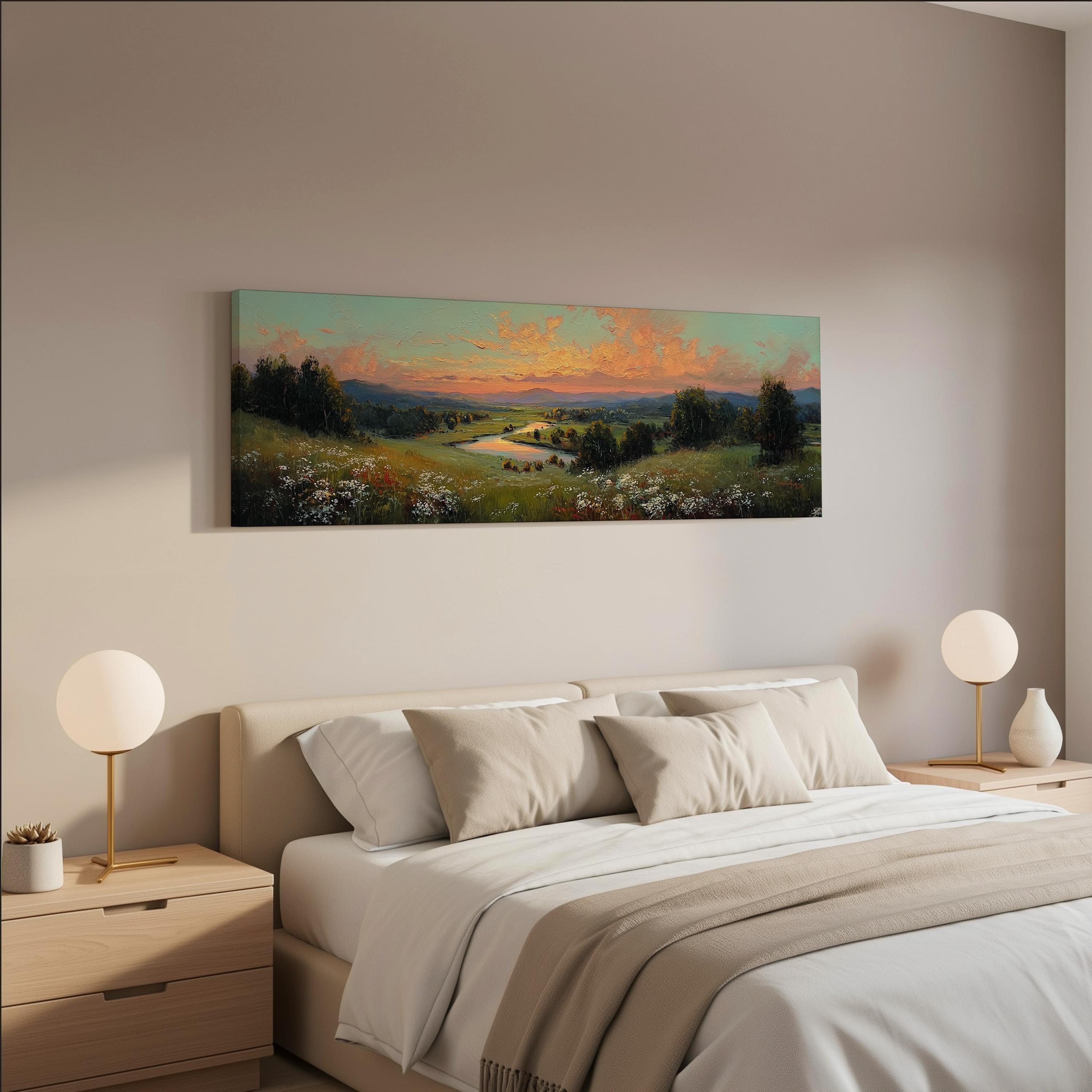 a serene bedroom scene with a large painting of a countryside landscape hanging on the wall above a bed with white bedding and beige pillows.