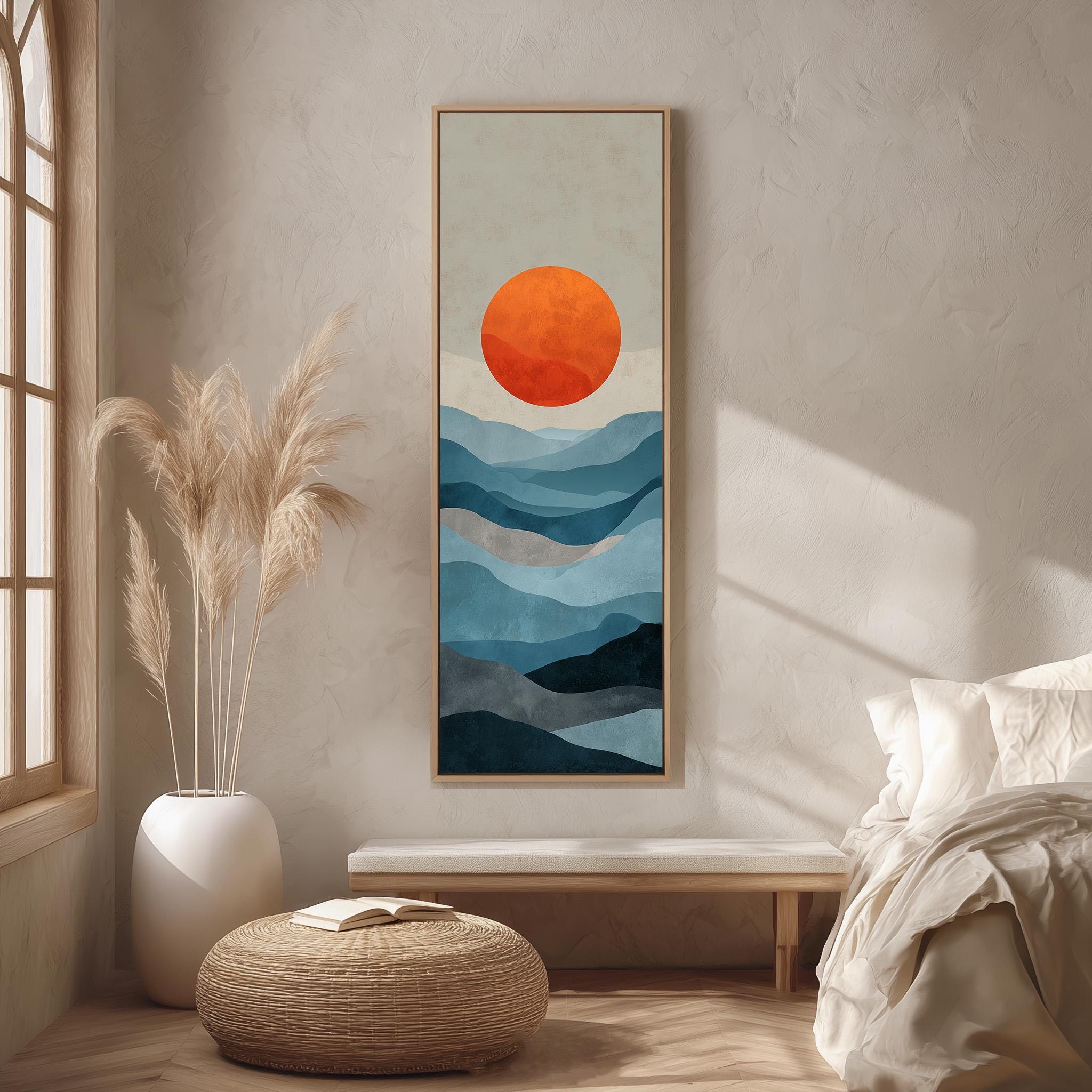 a serene bedroom setting with a large abstract painting of a sunrise over mountains hanging on the wall. The painting is framed in a wooden frame and is the focal point of the room. The room is decorated with a white bed, a wicker ottoman, and a potted plant, creating a calm and peaceful atmosphere.