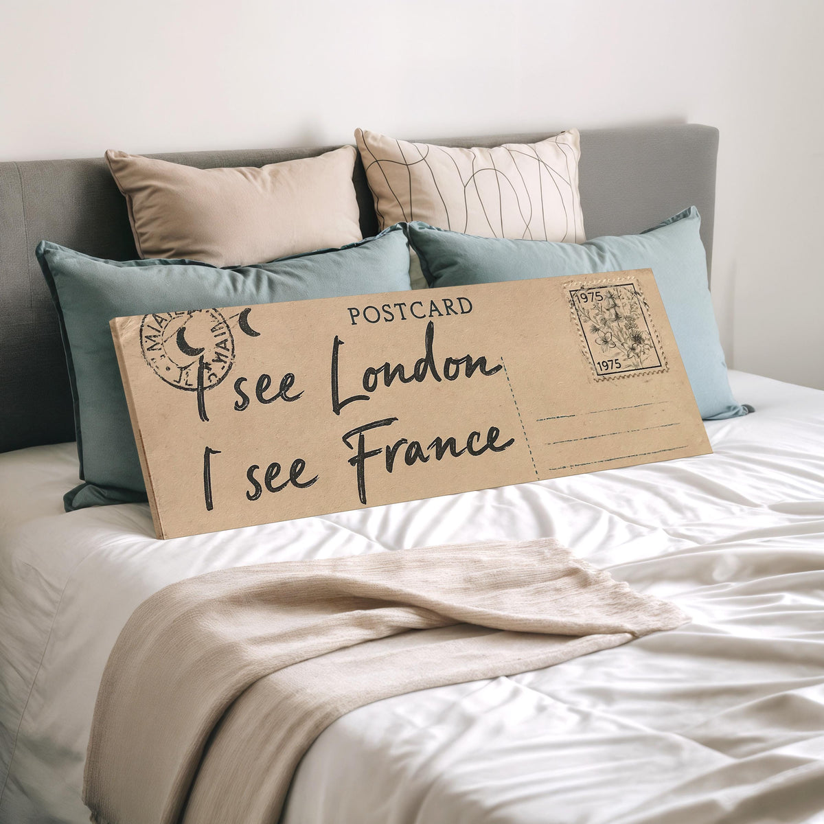 Postcard saying I see London, I see France wide panoramic canvas print laid on a bed to show its size