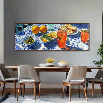 a dining table set with various food items and drinks, including oranges, a bowl of fruit, and glasses of what appears to be a refreshing beverage.
