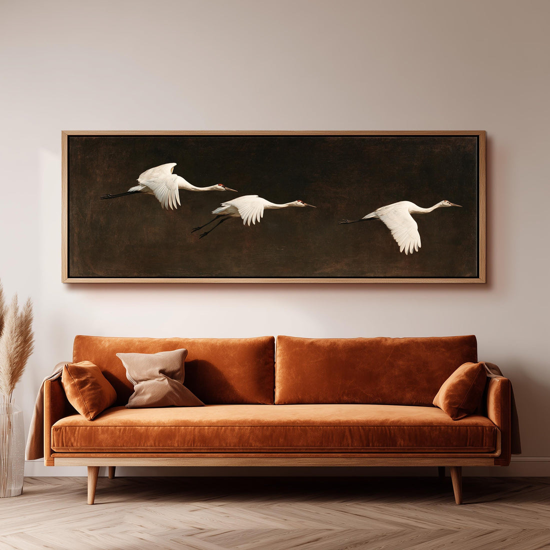 Three white egrets flying on a dark background long horizontal canvas print above a sofa in a living room