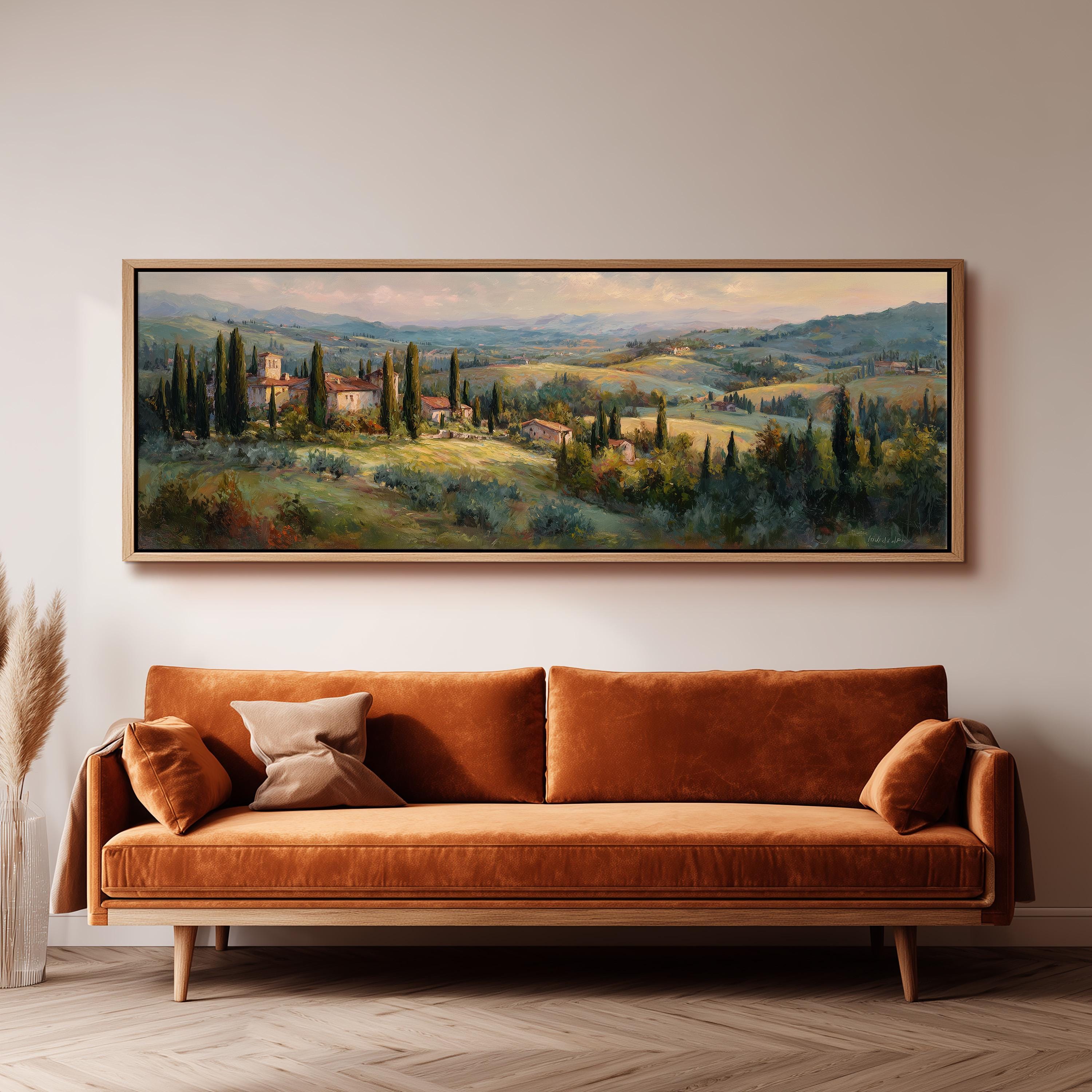 a large painting of a countryside landscape hanging on a wall above a brown sofa.