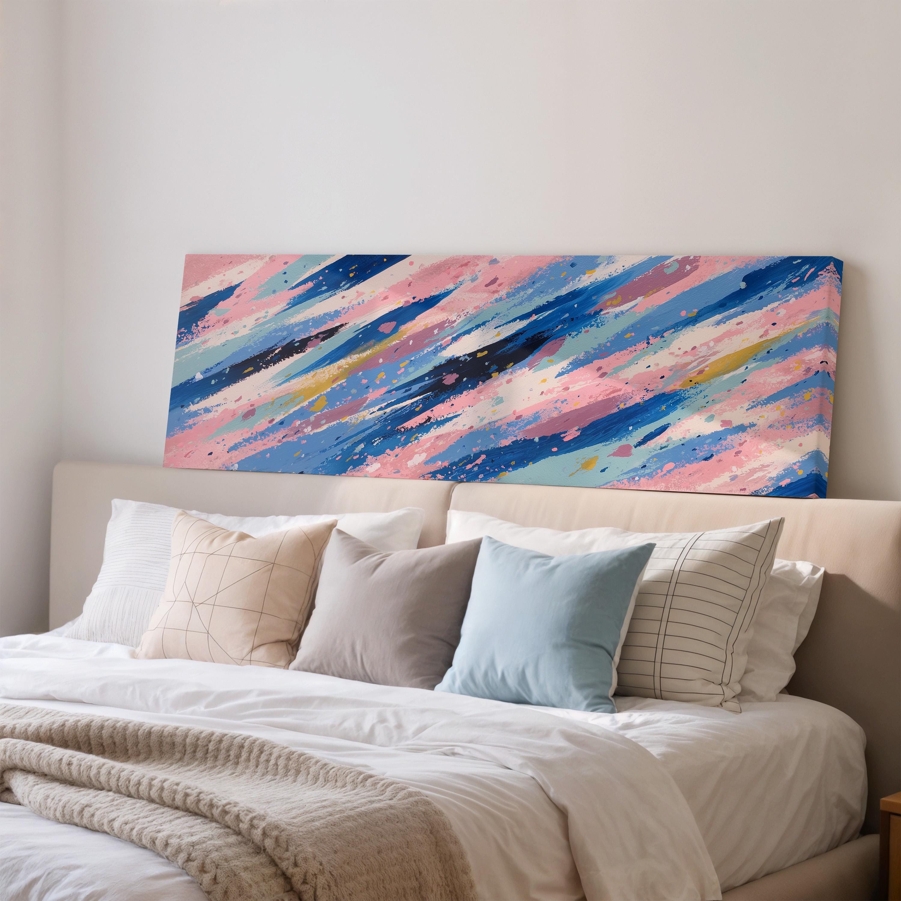 a large bed with a white comforter and a colorful abstract painting hanging above it.