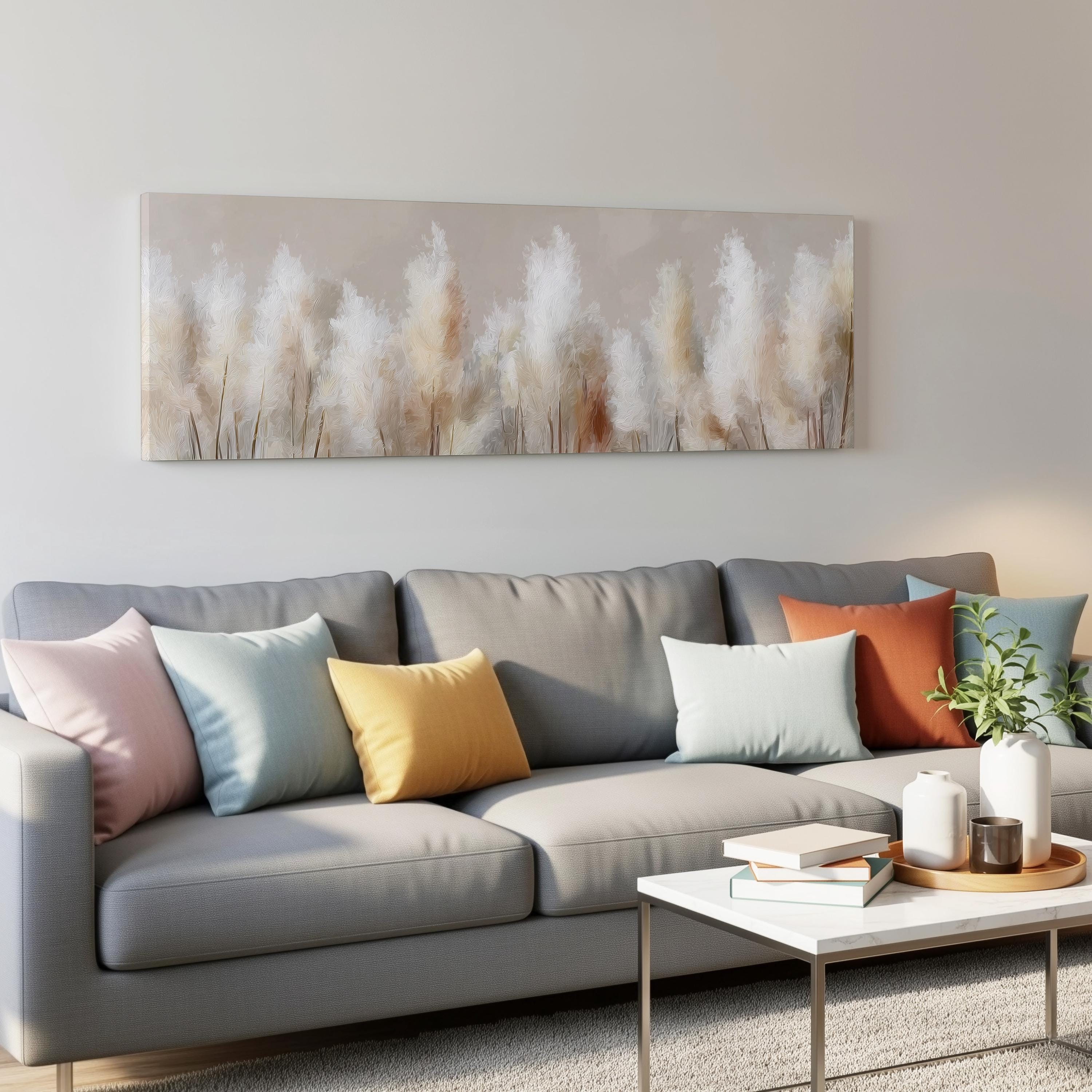 a modern living room with a gray sofa adorned with colorful throw pillows, a white coffee table, and a painting of tall grasses hanging on the wall above the sofa.