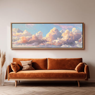 a large, framed painting of a cloudy sky hanging on a wall above a brown sofa.