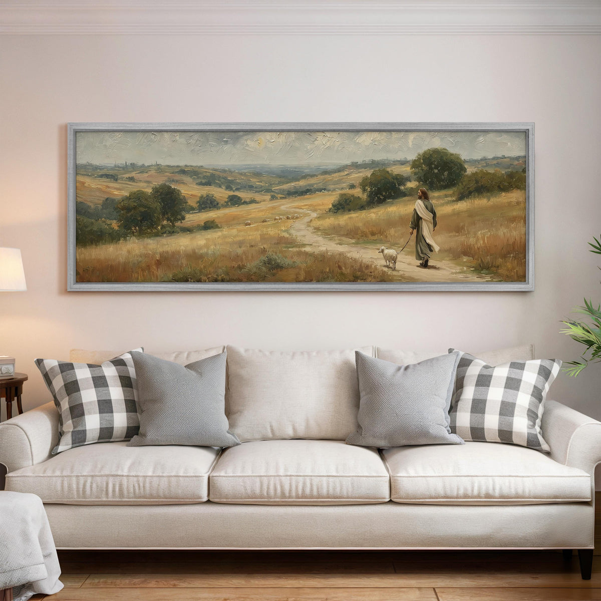 Jesus walking with a sheep on a golden hillside panoramic canvas print above a white sofa in a bright living room