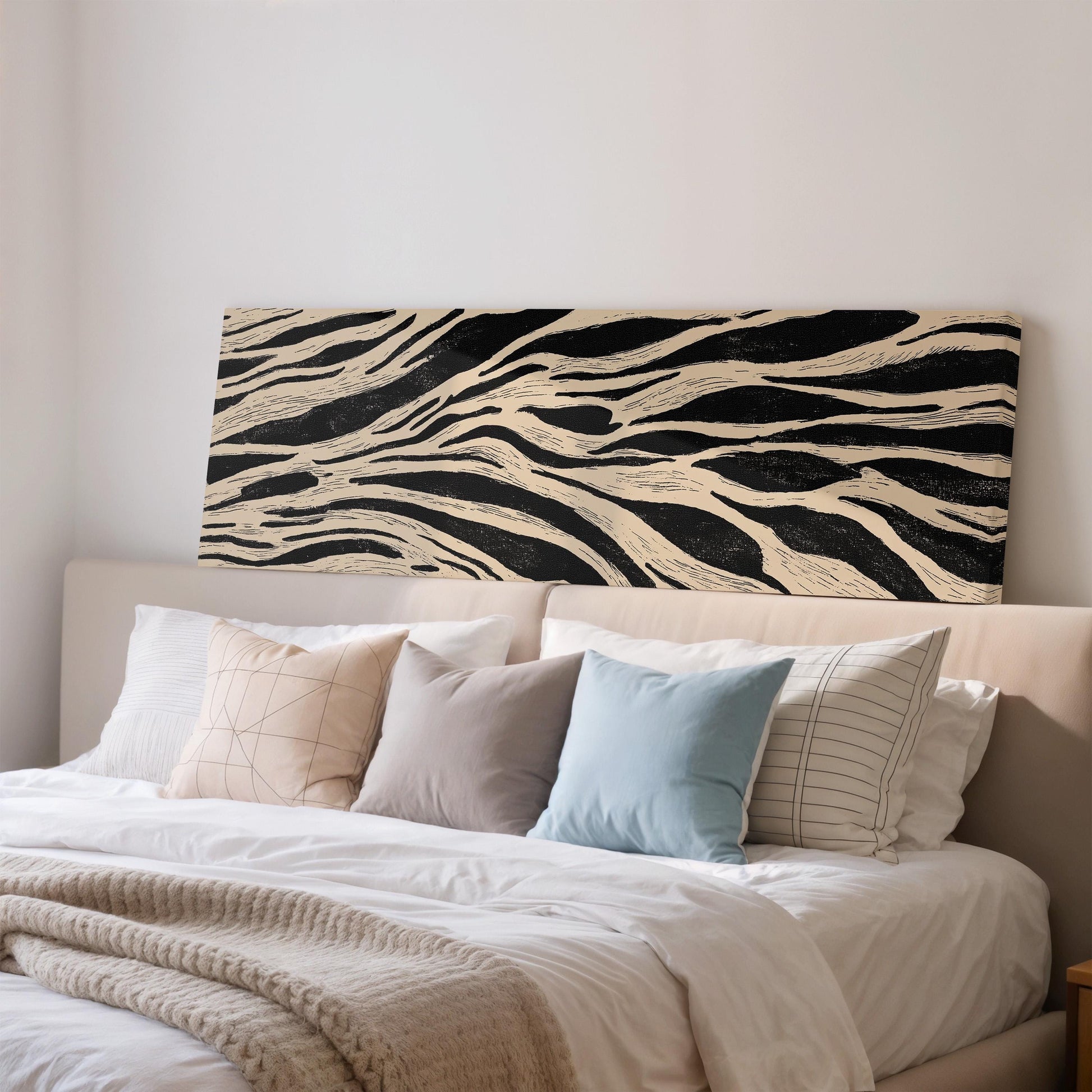 a large bed with a white comforter and a black and white zebra print headboard.