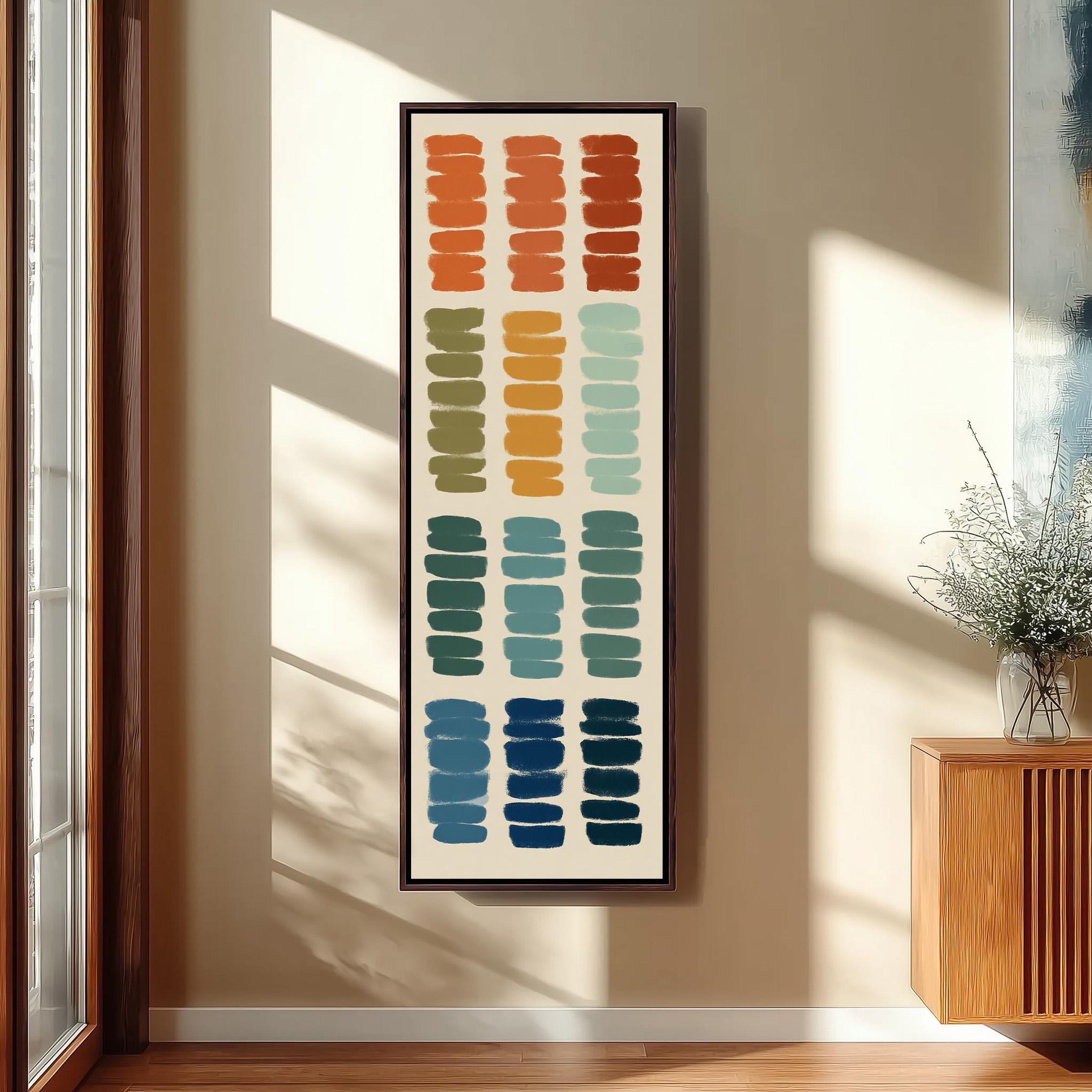 a large abstract painting hanging on a wall, with a wooden cabinet and a vase of flowers to the right of the painting.