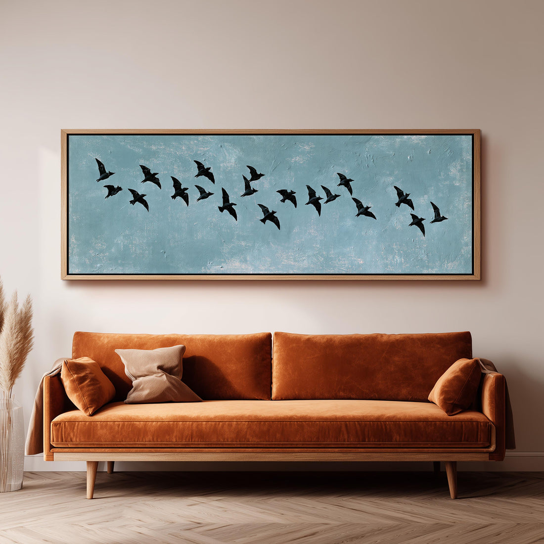 Flock of black birds on a teal sky long horizontal canvas print above a sofa in a living room